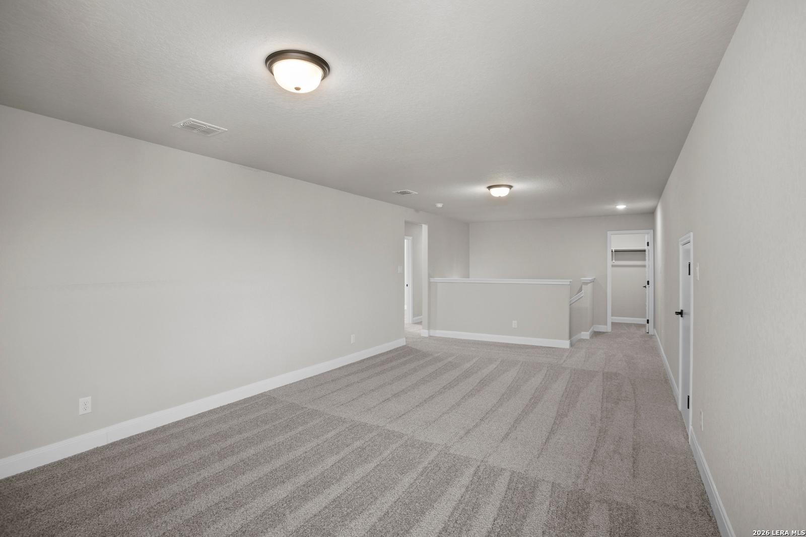 Spacious upstairs game room with plush carpeting in The Jennings G floor plan by Davidson Homes in Ladera, San Antonio.