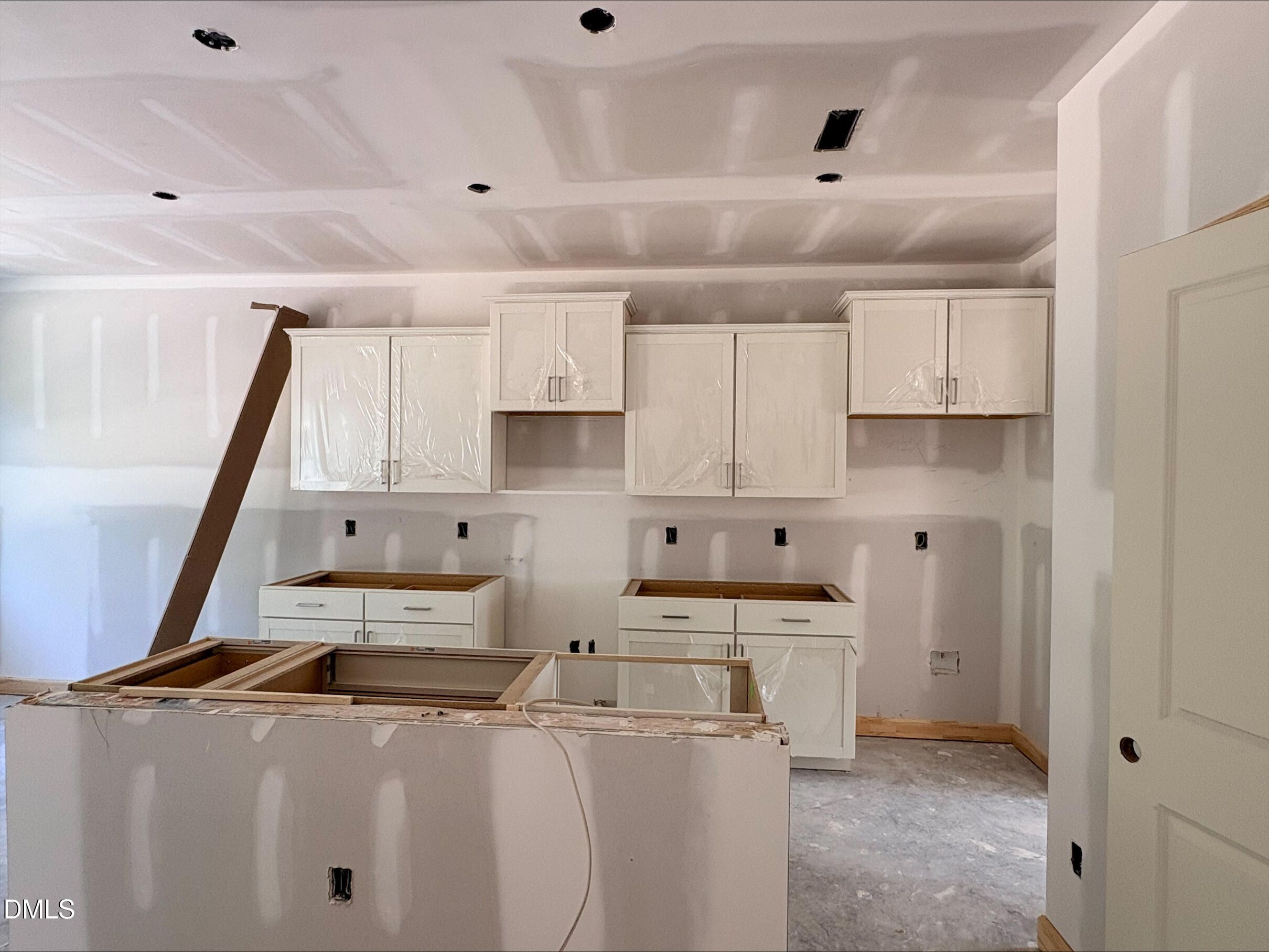 Kitchen under construction with white shaker cabinets and center island in The Willow B, Woodland Crossing, Zebulon, NC.