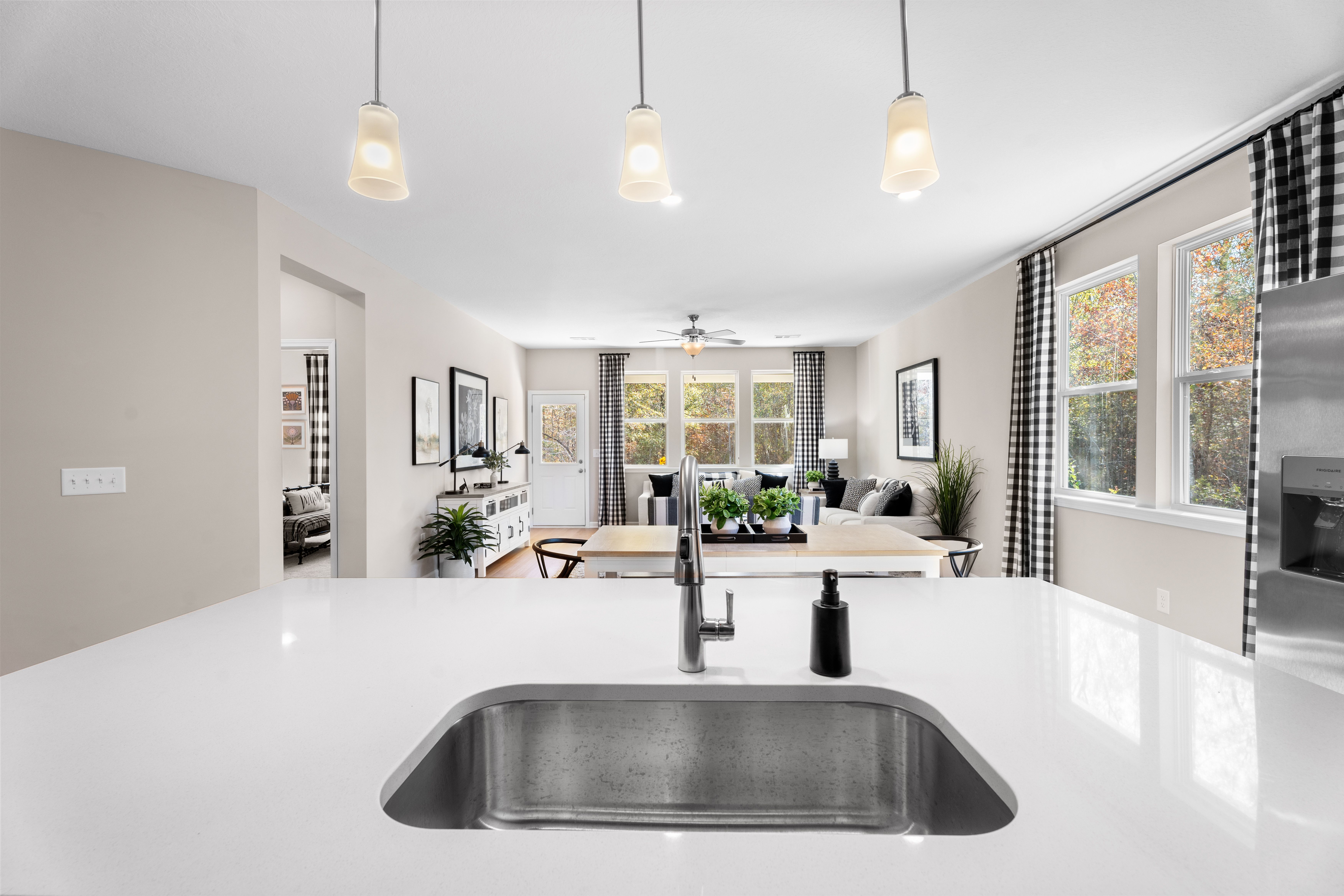 Spacious modern kitchen with dark cabinets, white island, black stools, stainless appliances, and hardwood floors at Silver Oak, Cusseta AL