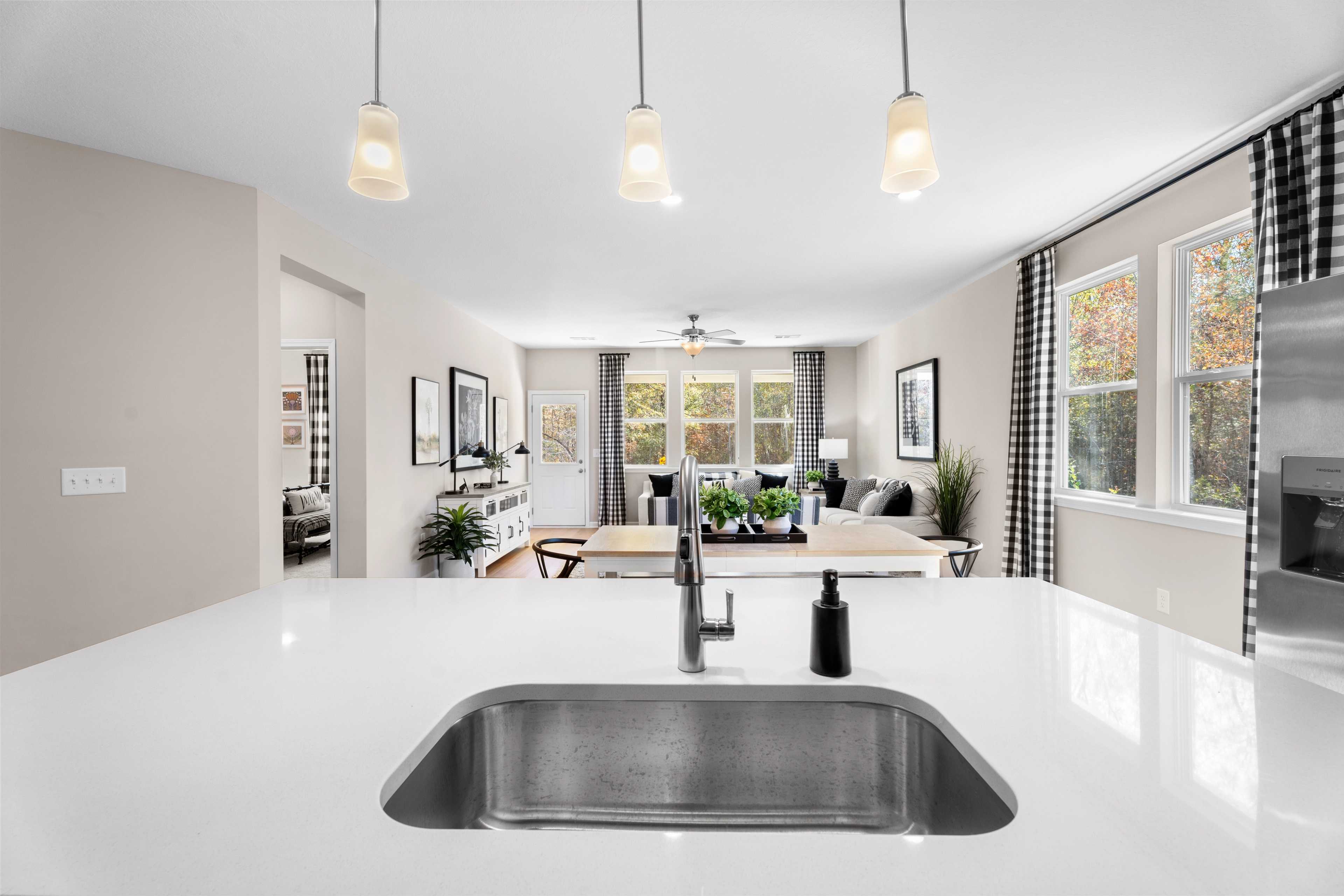 Spacious modern kitchen with dark cabinets, white island, black stools, stainless appliances, and hardwood floors at Silver Oak, Cusseta AL