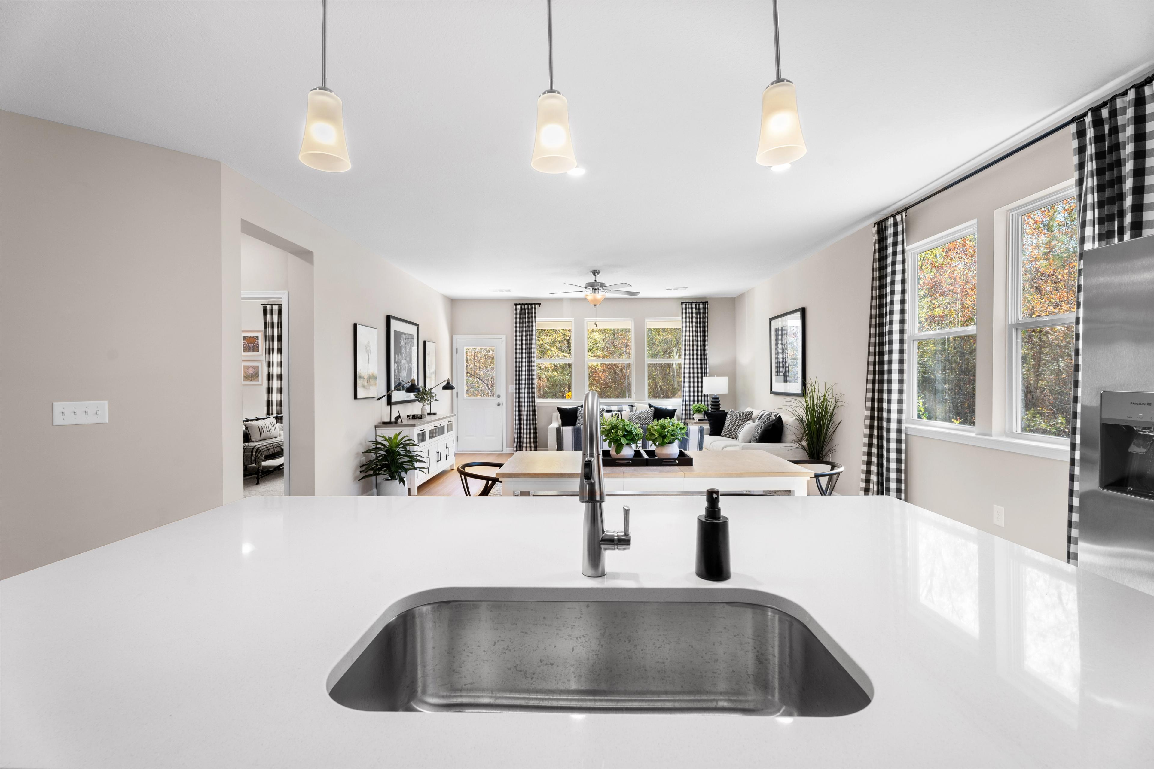 Spacious modern kitchen with dark cabinets, white island, black stools, stainless appliances, and hardwood floors at Silver Oak, Cusseta AL