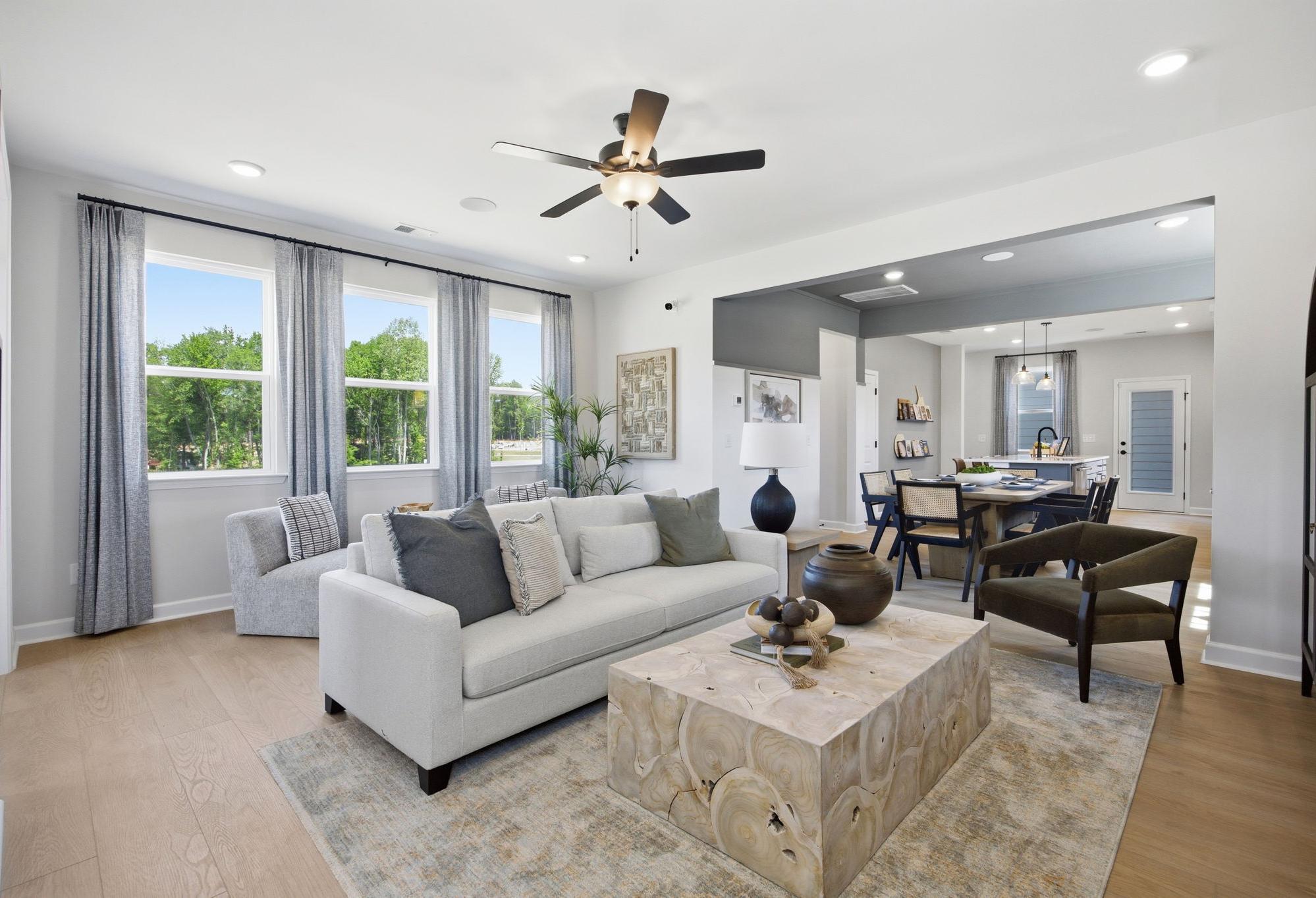 Open-concept living room in The Burke floor plan by Davidson Homes featuring a modern kitchen and dining area.