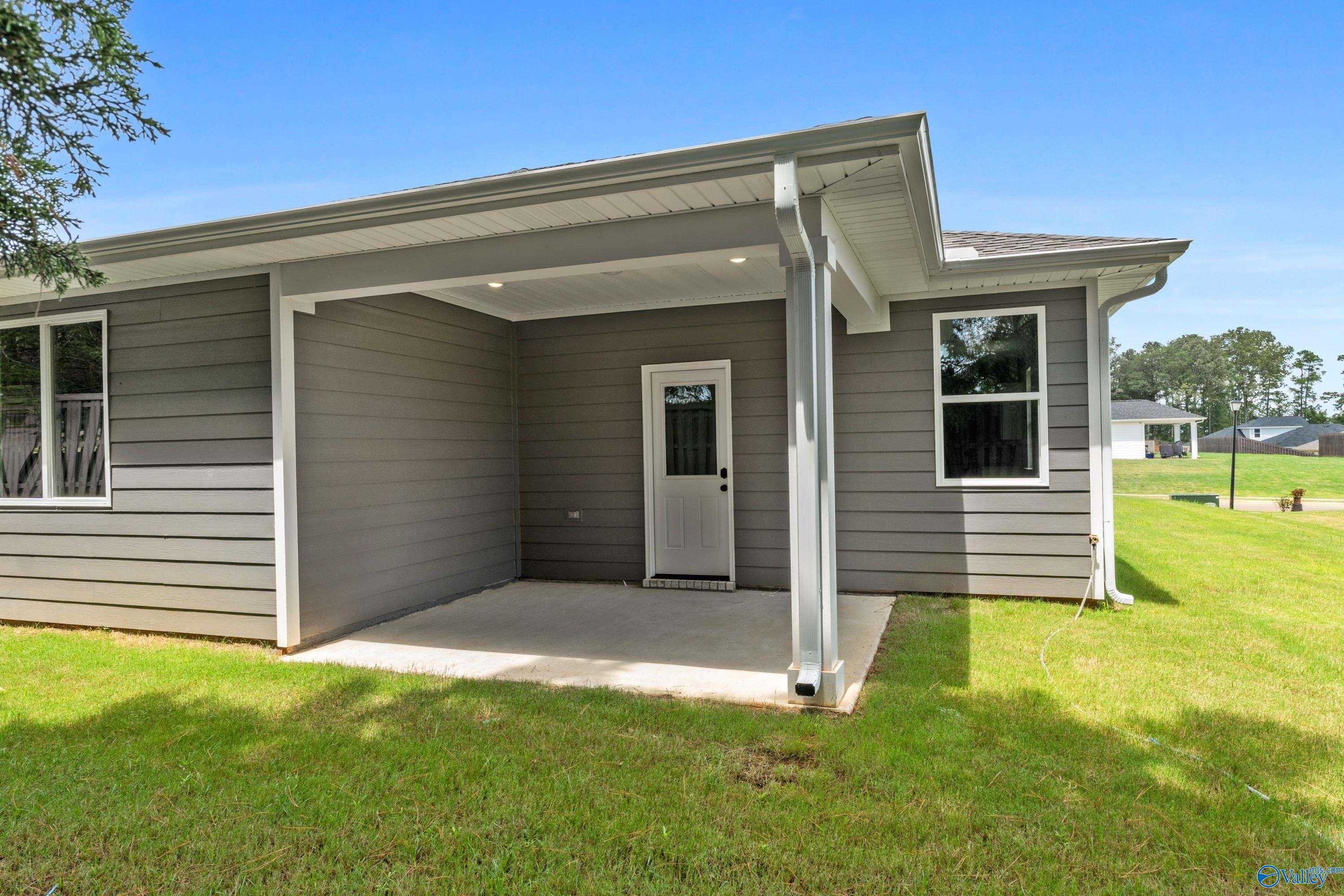Modern gray-sided Nantucket home with covered garage, side entrance, and green lawn in Evergreen Mill, Madison, Alabama