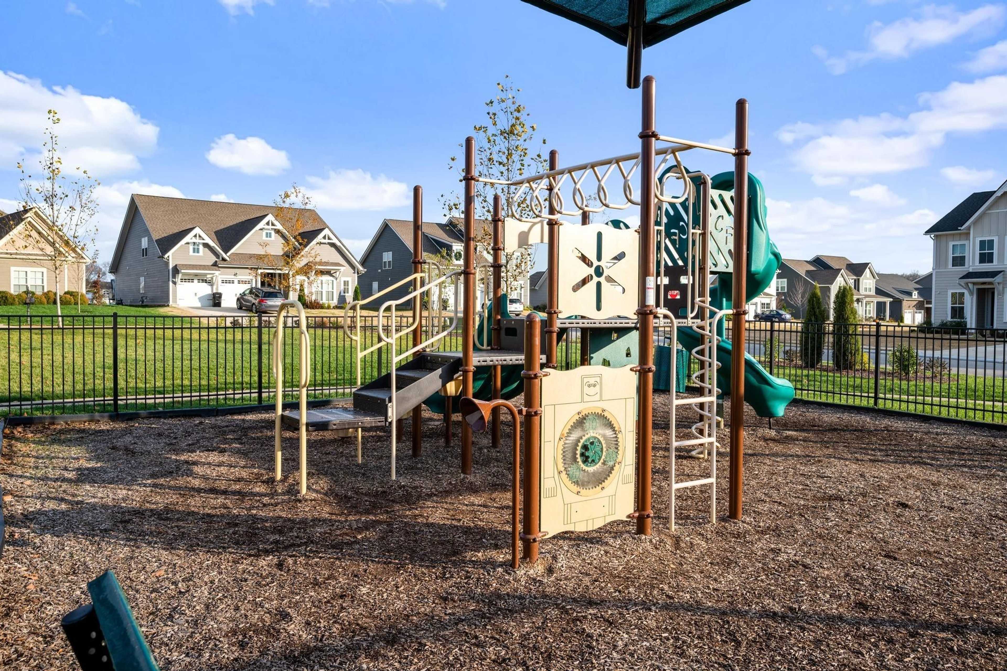 Children's playground at Shelton Square in Murfreesboro TN with slides, climbing walls and play structures amid neighborhood homes