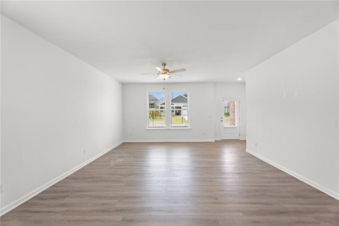 Spacious, light-filled living room with wood-style flooring in The Stella D floor plan at Silver Oak in Cusseta, Alabama.