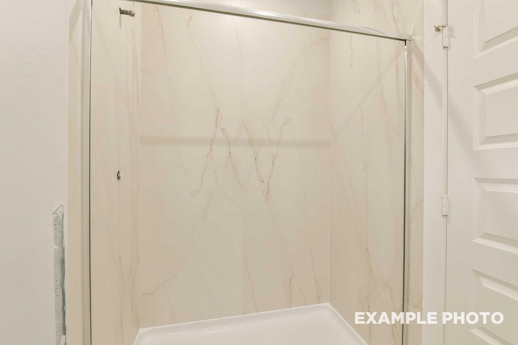 Modern marbled glass shower enclosure with framed door in master bath, Davidson Homes The Colorado G, Conroe Texas