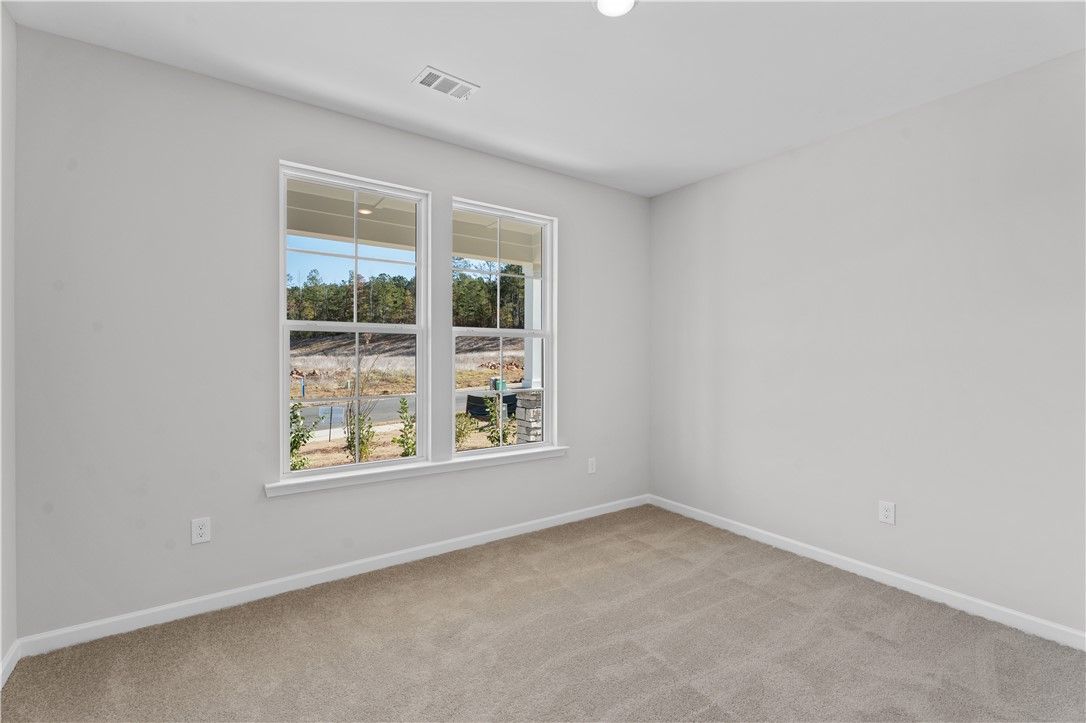Bright empty bedroom with large double windows and lake view in The Luna B 4-bedroom home, Opelika, Alabama