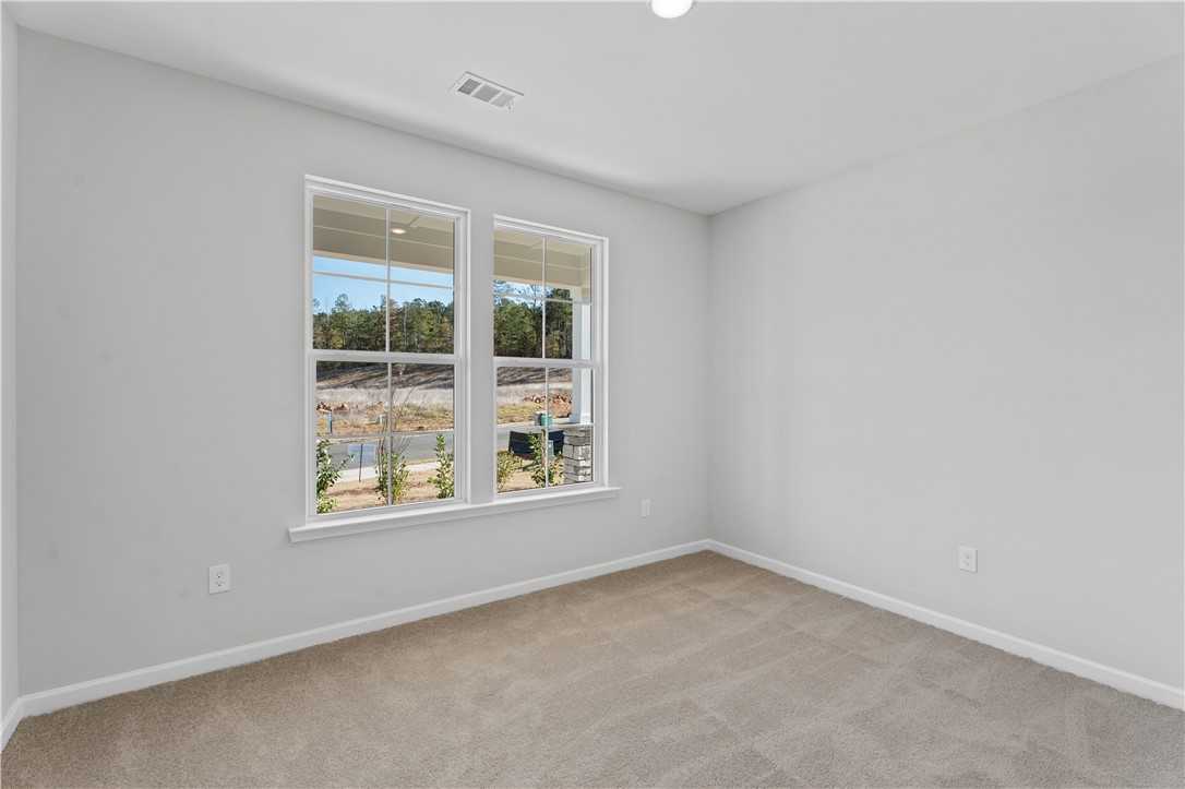 Bright empty bedroom with large double windows and lake view in The Luna B 4-bedroom home, Opelika, Alabama