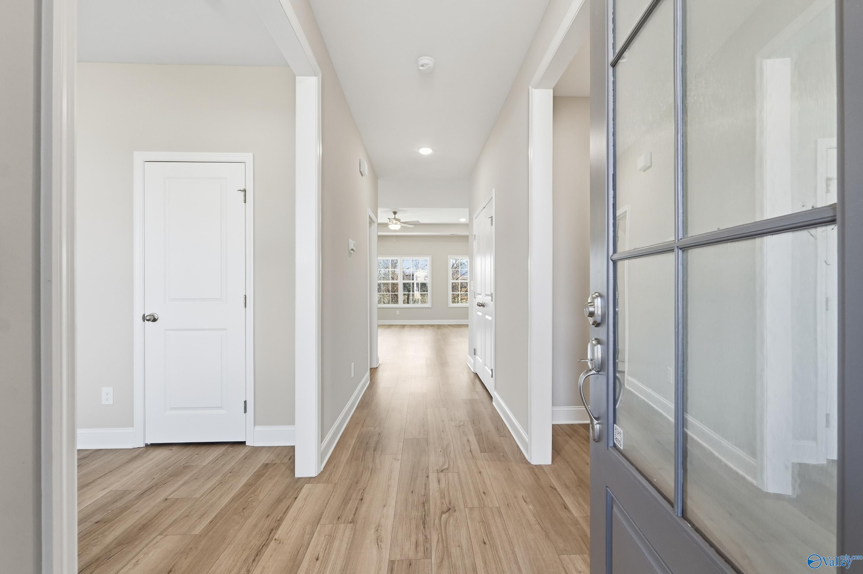 Bright hallway with hardwood floors, arched doorways, and glass front door in Davidson Homes The Rockford, Creekside, Harvest, AL