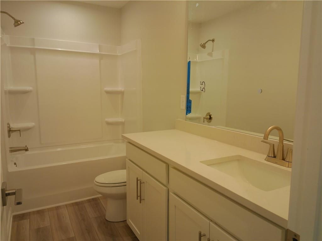 Modern bathroom with tub-shower combo, white quartz vanity, gold faucet in Davidson Homes The Marion C, Winder Georgia