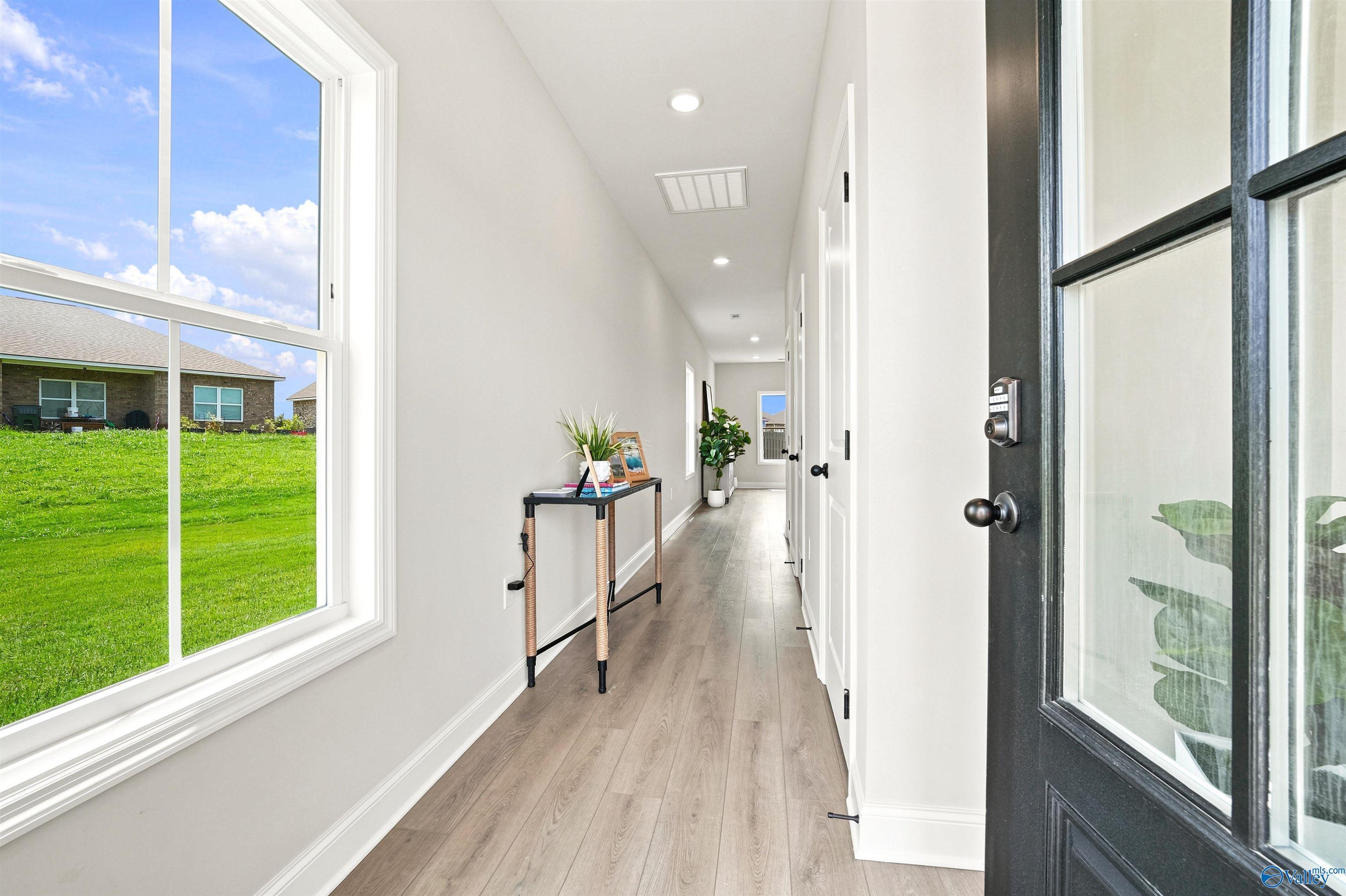 Bright, modern entryway hallway with wood-style flooring in The Burton B floor plan at Heritage Lakes, New Market, Alabama.