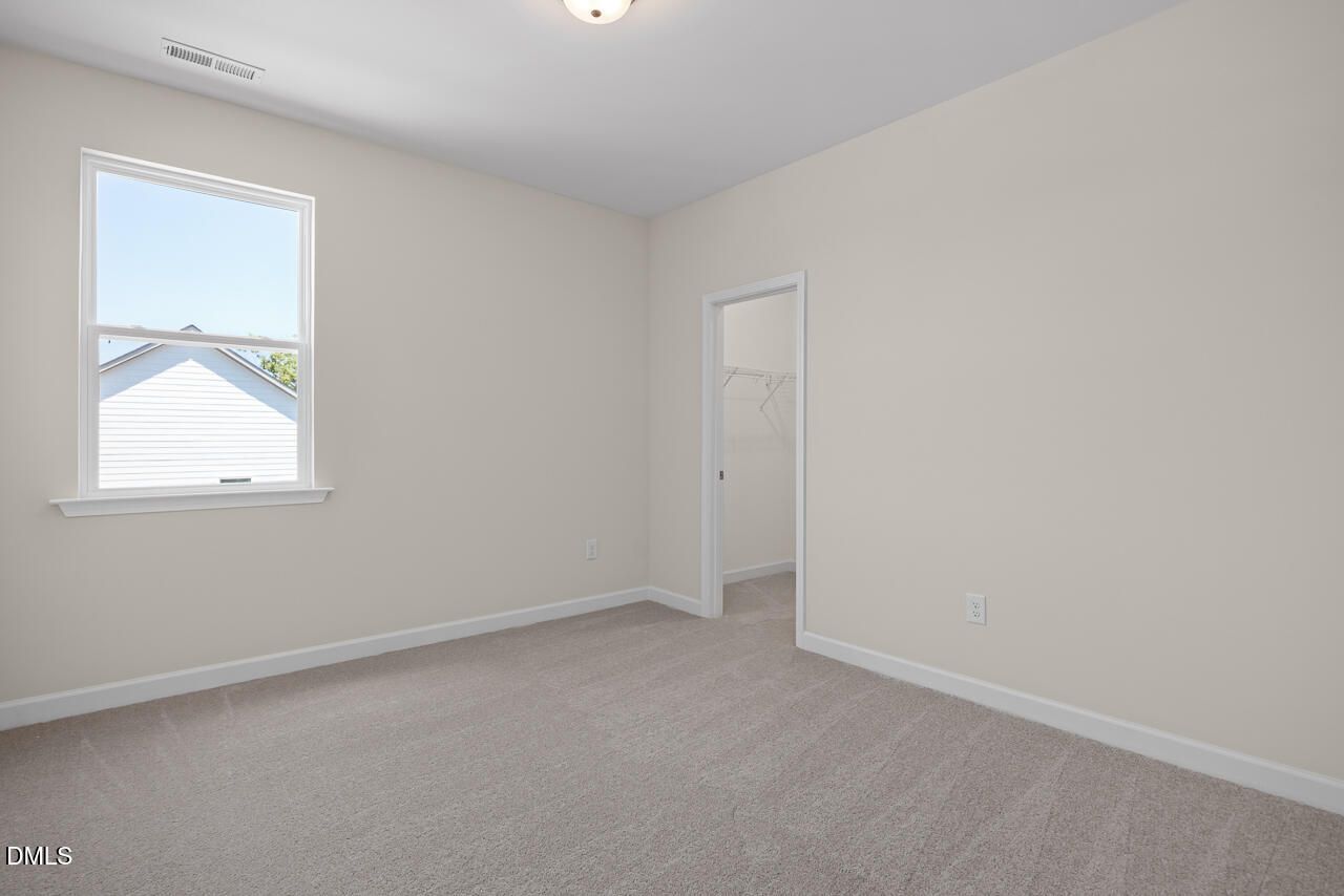 Bright secondary bedroom with plush carpet and walk-in closet in The Hickory II B by Davidson Homes, Montrose, Aberdeen.