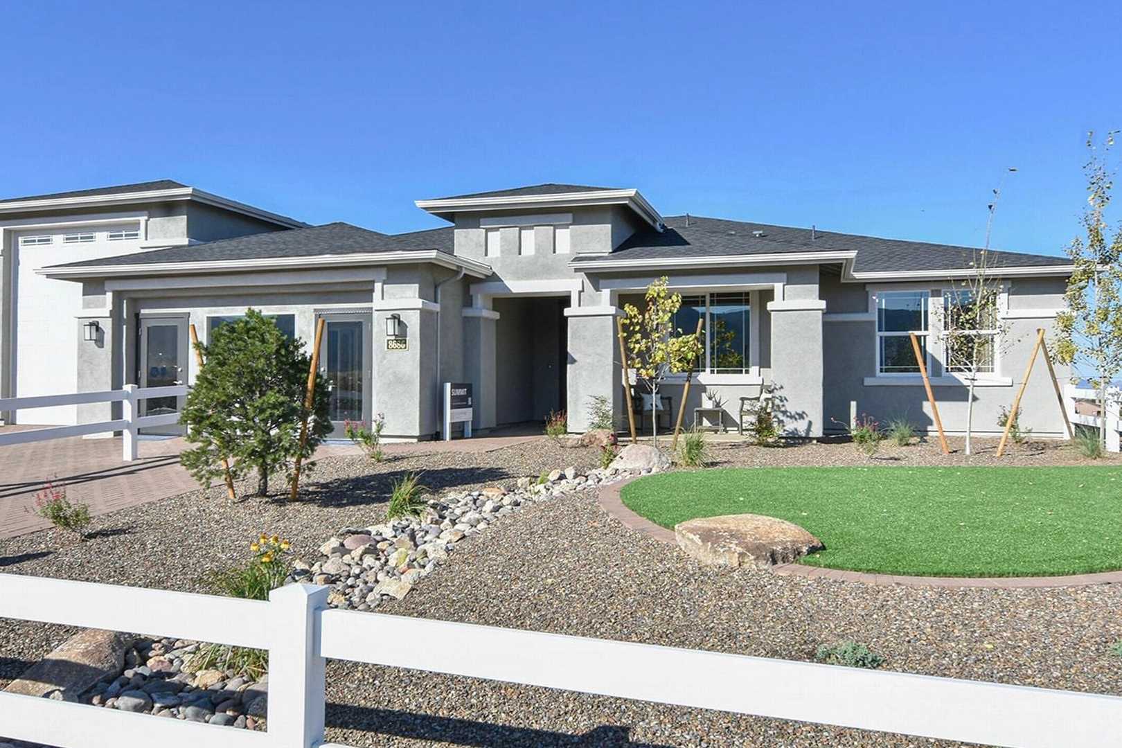 Contemporary single-story home exterior at Morningstar in Prescott Valley AZ by Evermore Homes with desert landscaping and white fence