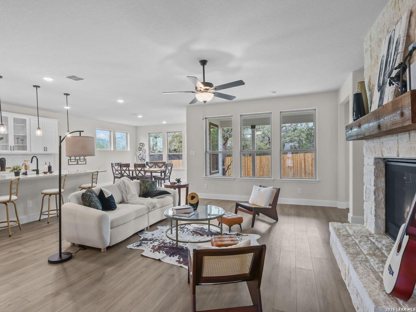Open-concept living room with stone fireplace in The Belmont H floor plan by Davidson Homes, Potranco Oaks, Castroville.