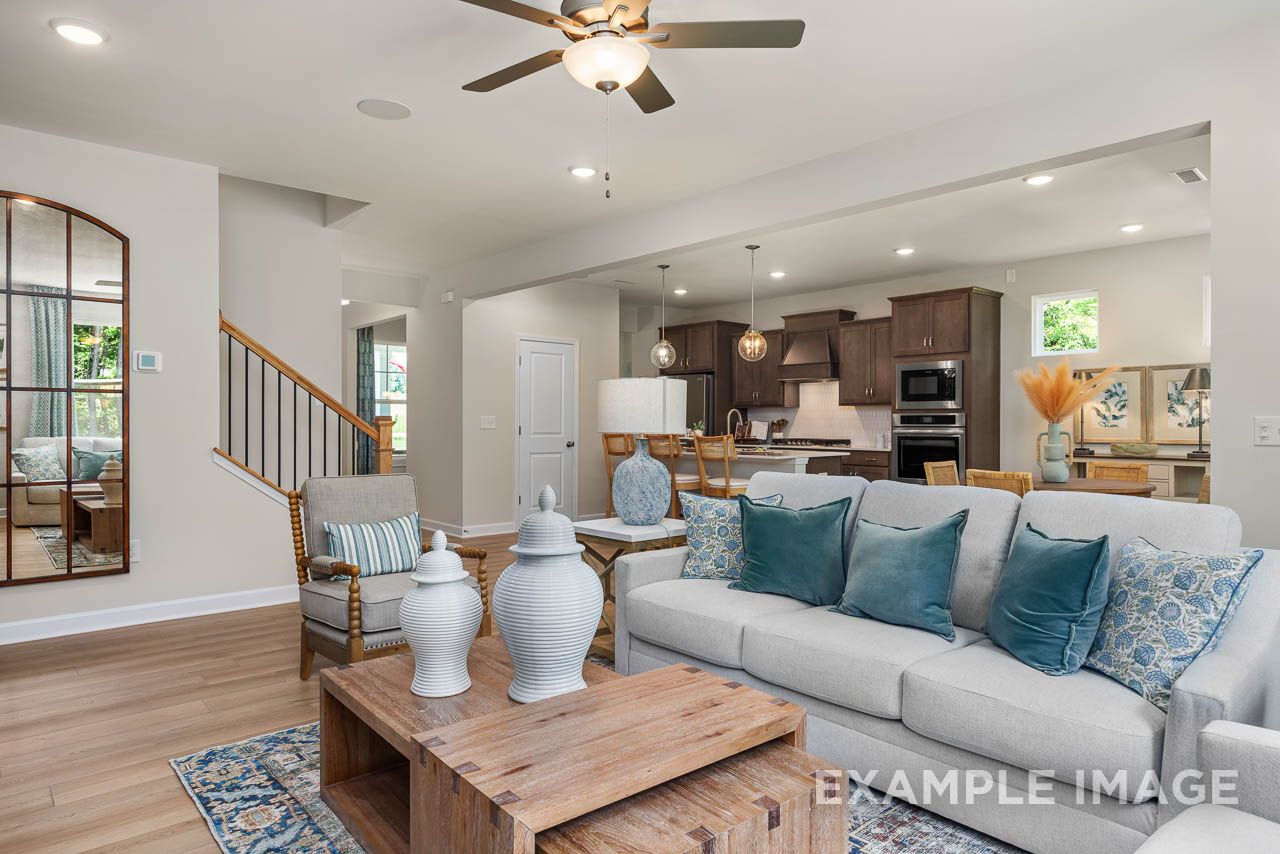 Open-concept living room and kitchen in The Willow C-BF by Davidson Homes with hardwood floors and staircase