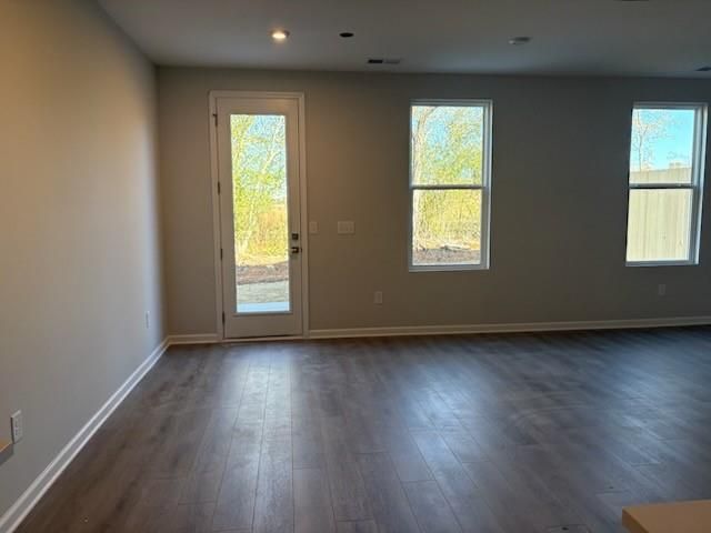 Bright living room with hardwood floors, sliding glass door to backyard, and large windows in Marion A home, Winder, Georgia