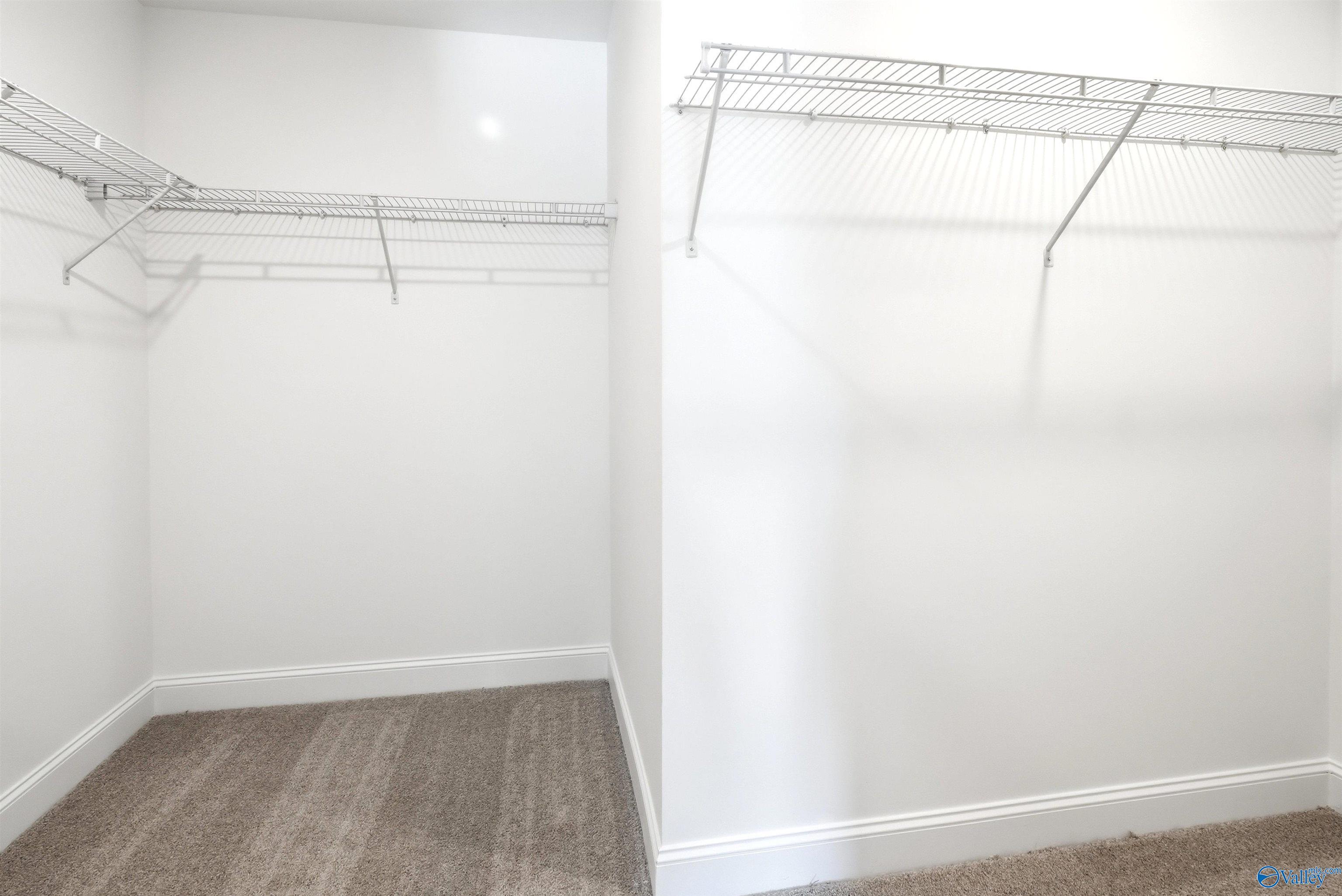 Spacious walk-in closet with wire shelving and carpet flooring in Davidson Homes The Russell A plan at Spragins Cove, Huntsville, AL