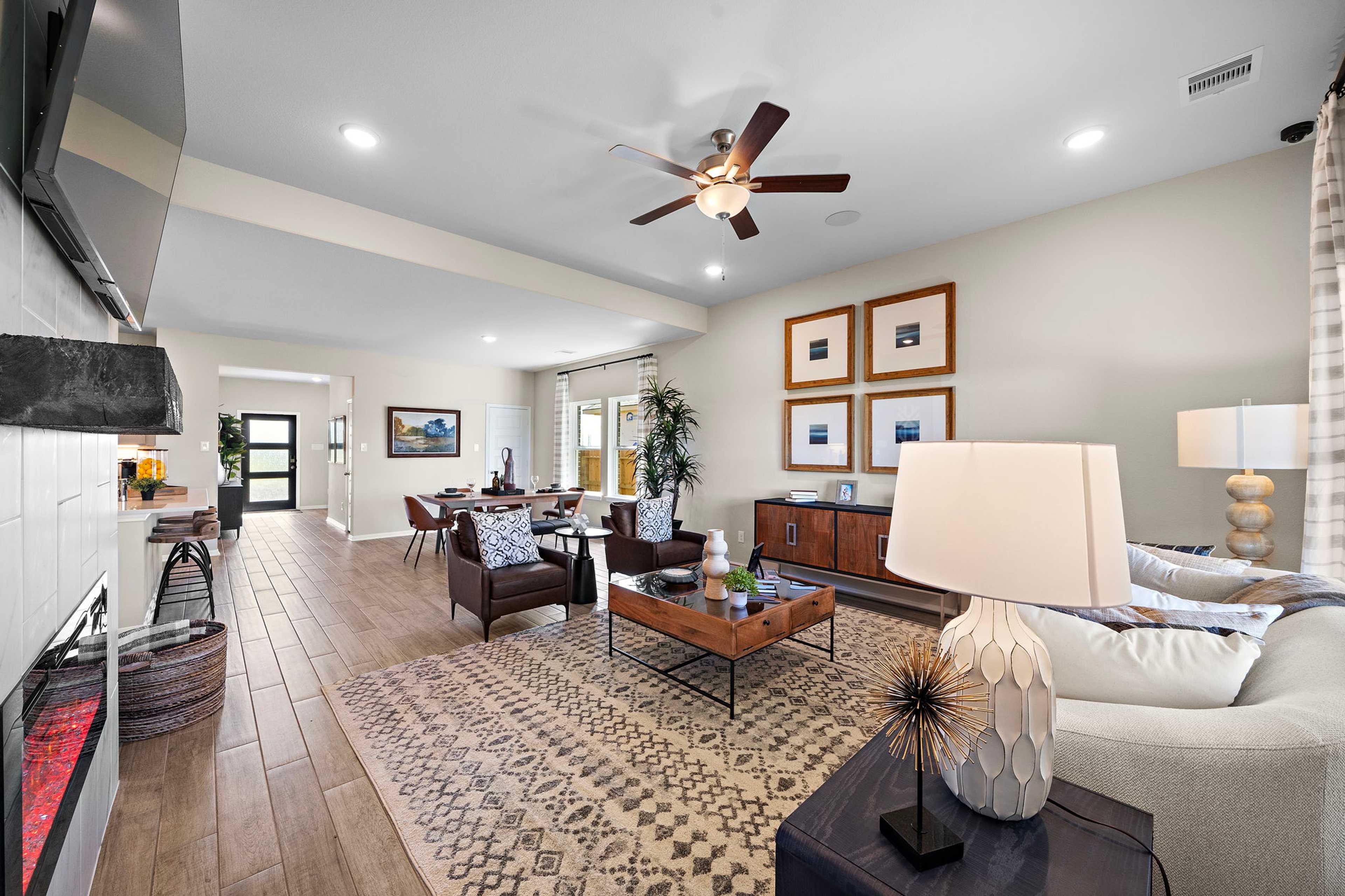 Open-concept living and dining area in Emberly Beasley Texas with hardwood floors ceiling fans modern furniture and neutral decor