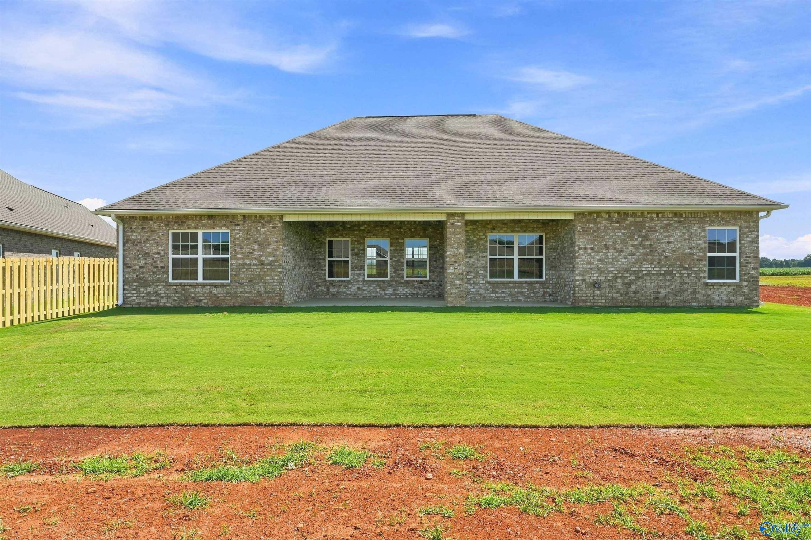 Brick exterior of The Oxford floor plan home with spacious backyard and covered patio in Kendall Farms, Toney, Alabama.