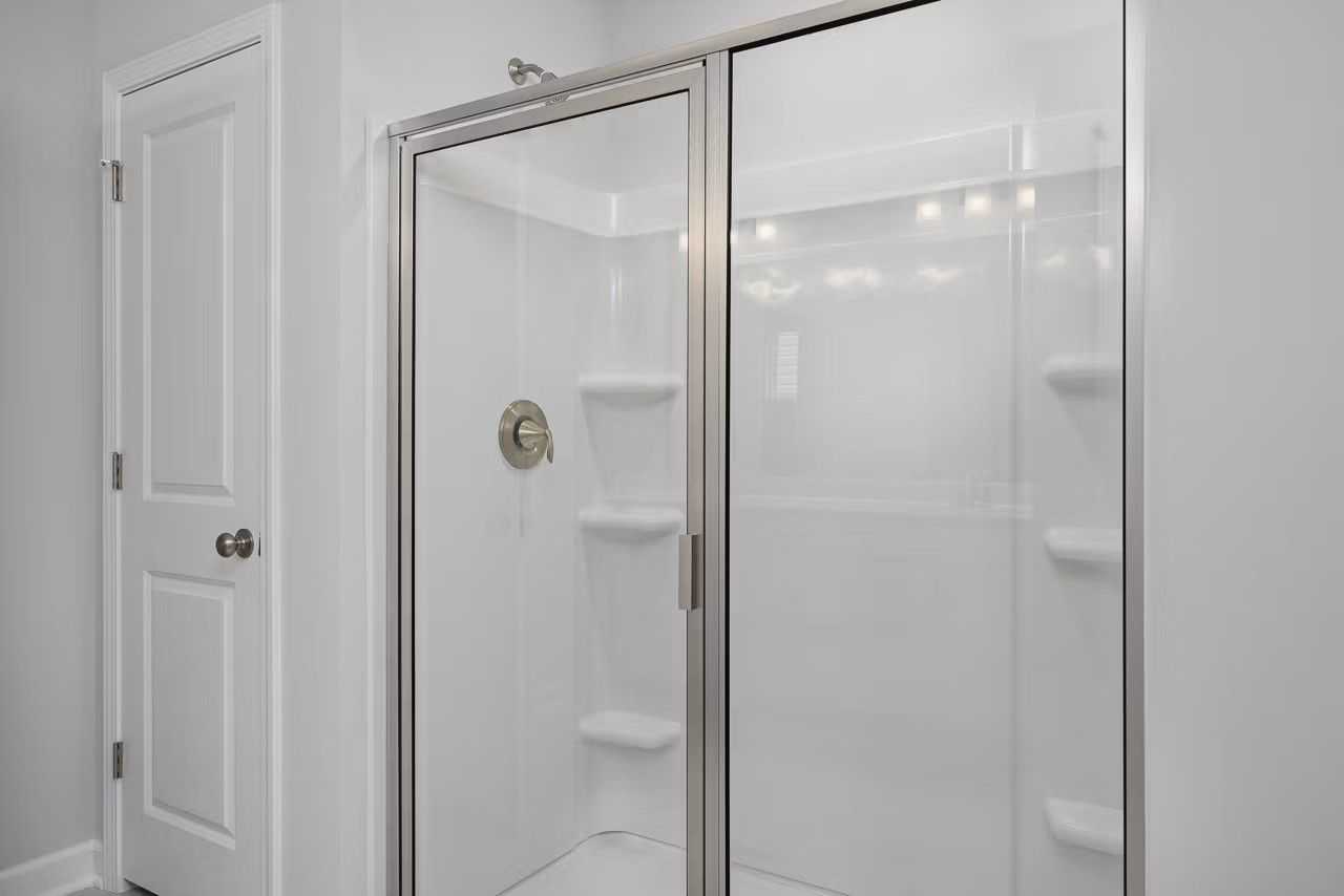 Modern glass shower enclosure with built-in shelves and white tile in master bath, Davidson Homes The Durham C, Wylie TX