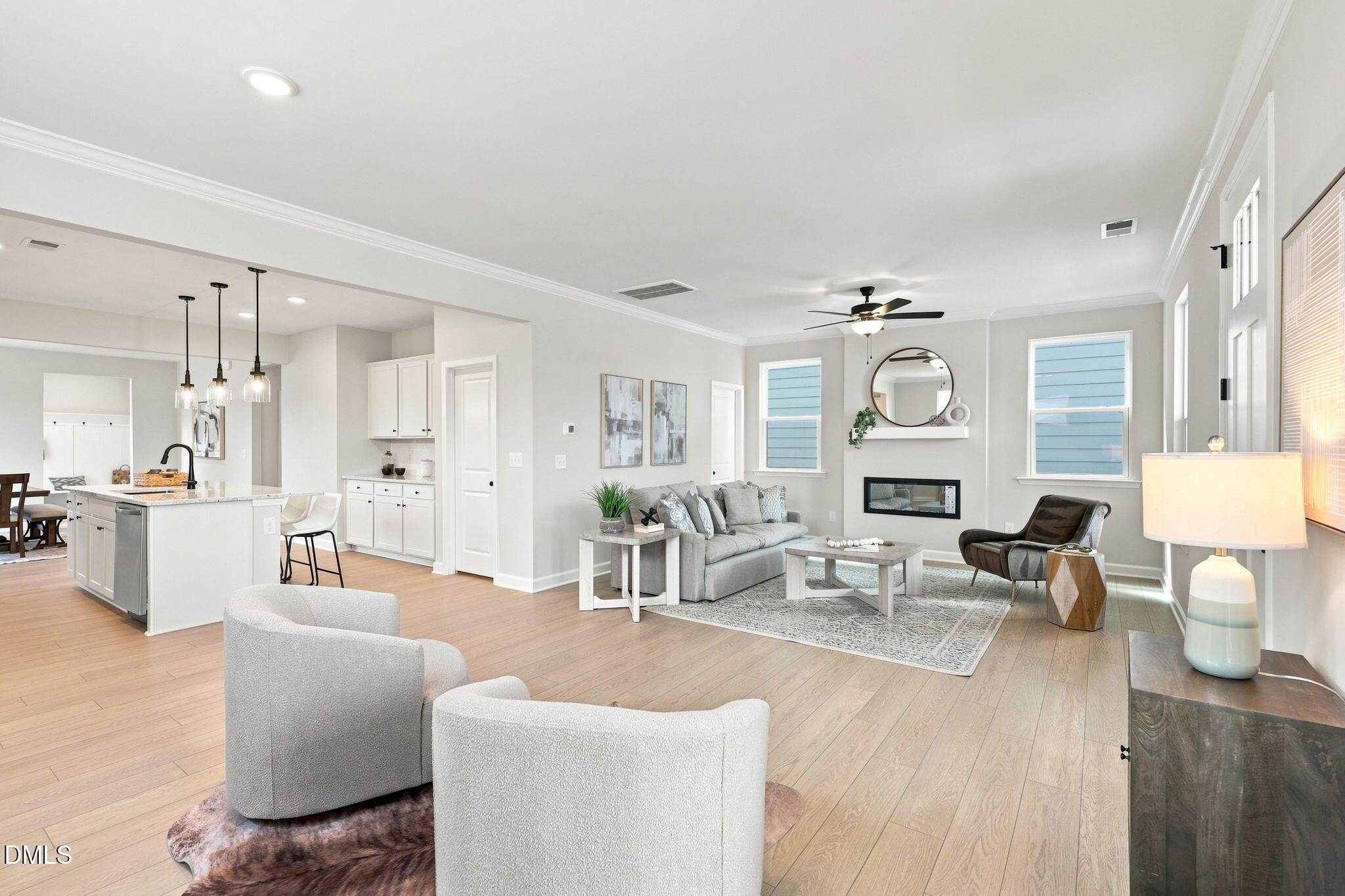 Open-concept living room with fireplace and kitchen in The Harris C floor plan at Forestville Yard, Knightdale, NC.