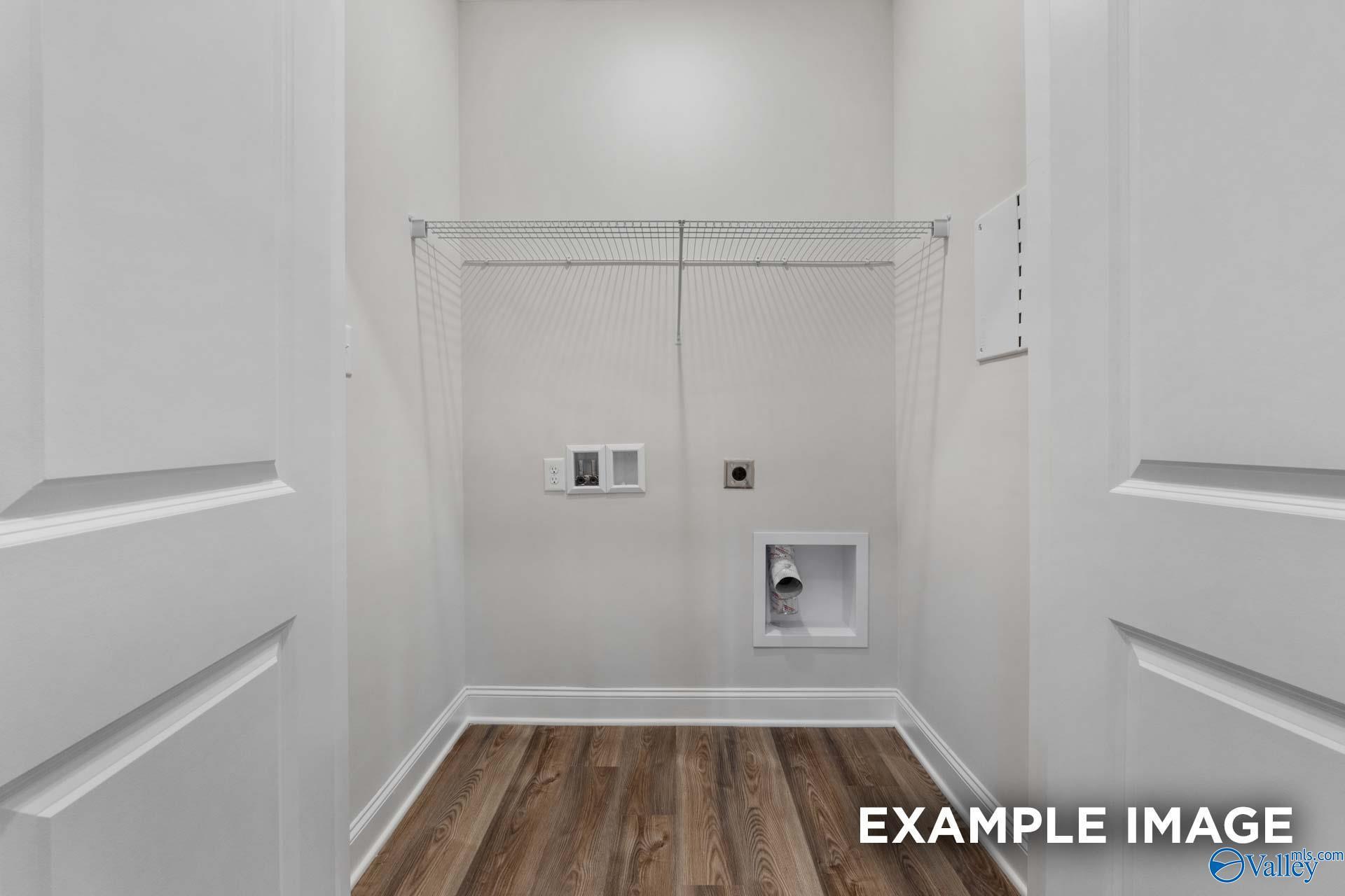 Bright laundry room with utility sink, washer-dryer hookups, and wood flooring in Davidson Homes Cumberland B, Decatur AL
