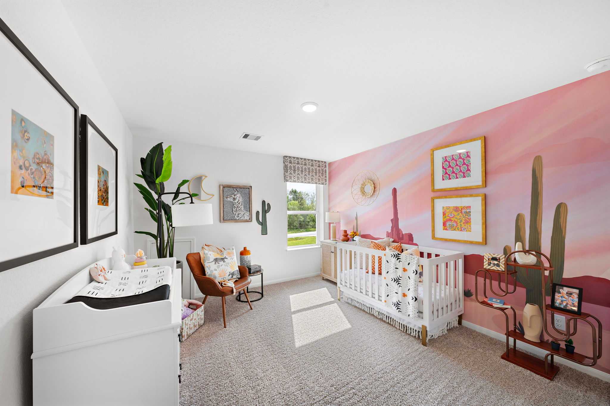 Desert-themed nursery at The Villages at WestPointe in Dayton Texas with pink cactus mural, white crib, and changing table
