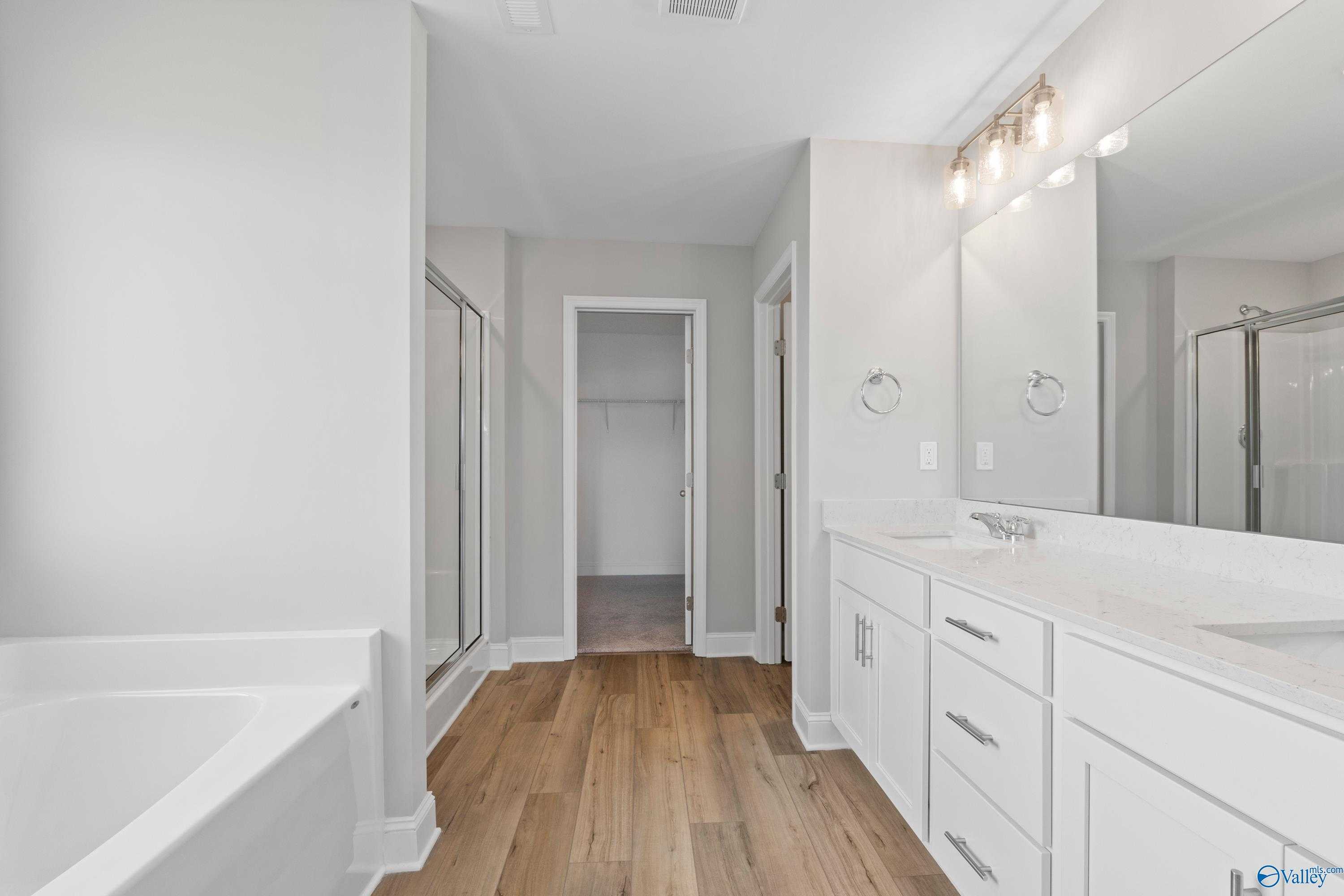 Luxurious master bathroom featuring freestanding tub, glass shower, double vanity in Davidson Homes The Chelsea B, New Market, AL