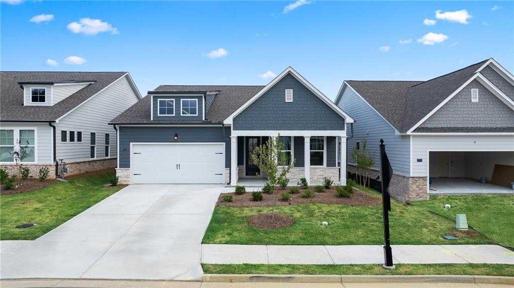 Modern gray-sided 1-story home with 2-car garage, driveway, and landscaped yard in Kelly Preserve, Loganville, Georgia
