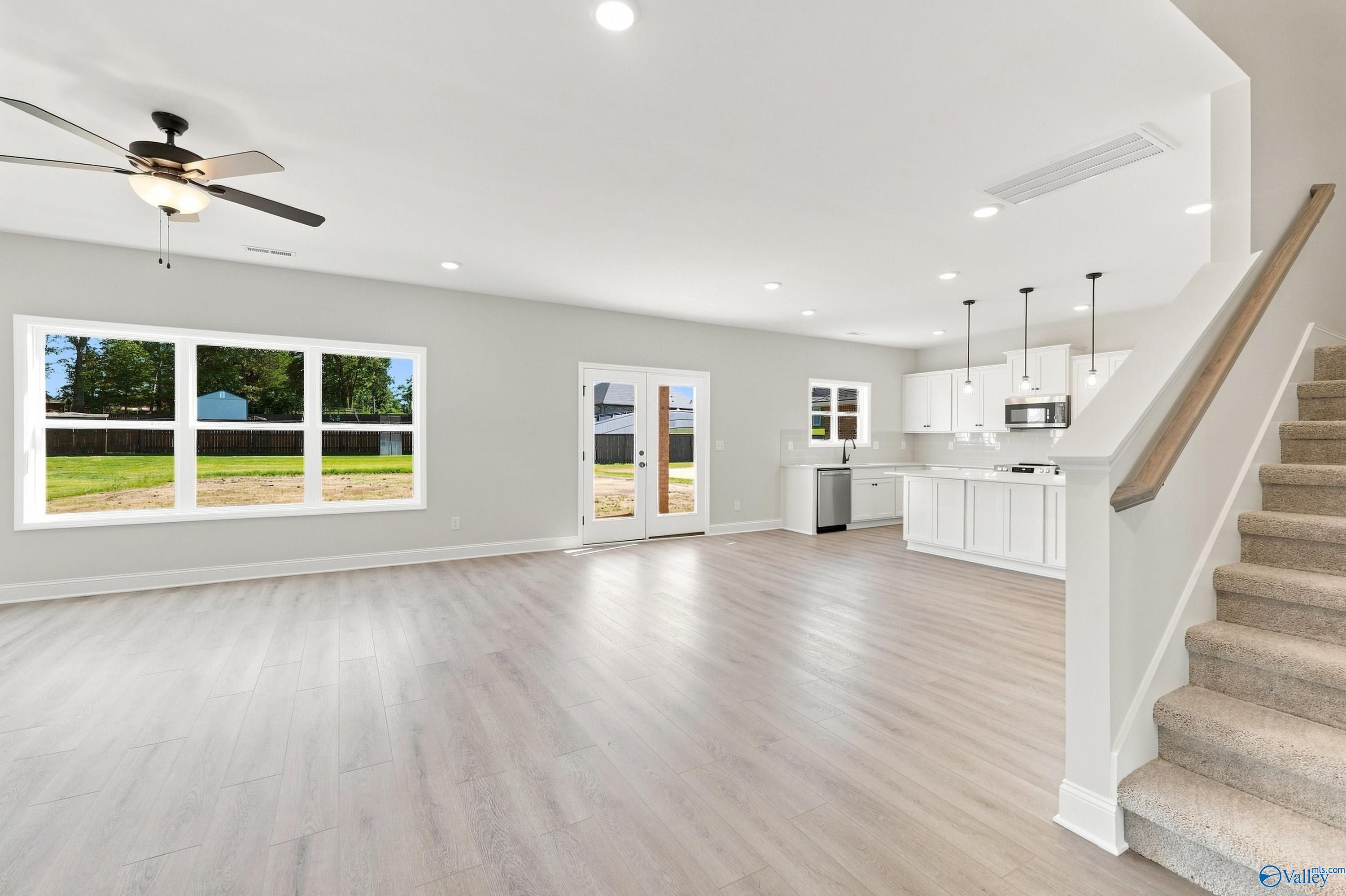 Bright open-concept living room and kitchen with luxury vinyl flooring in Davidson Homes' Chelsea B floor plan, New Market, Alabama