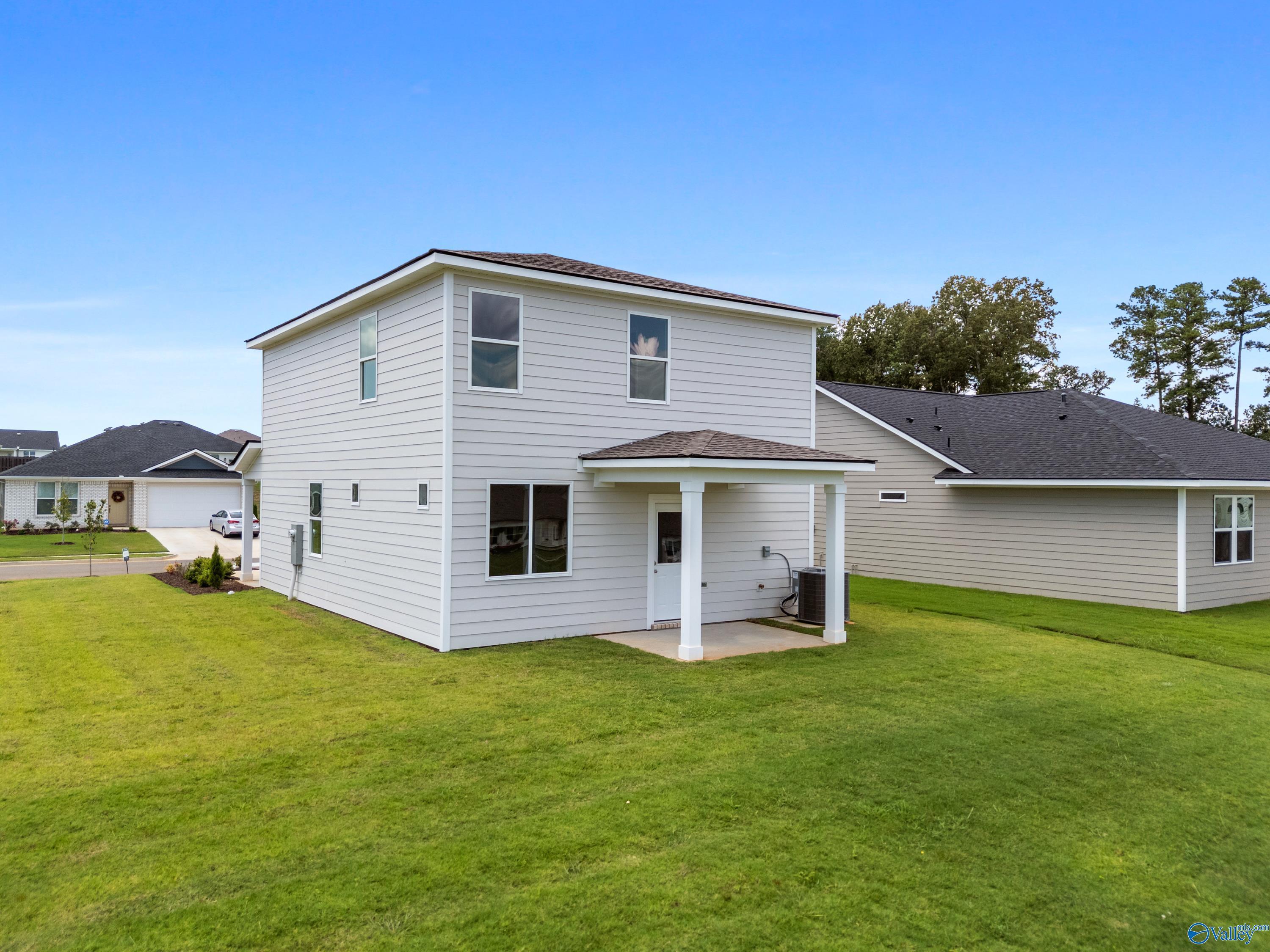 Two-story Augusta floor plan home exterior with covered porch, garage, and lush lawn in Evergreen Mill, Madison, Alabama