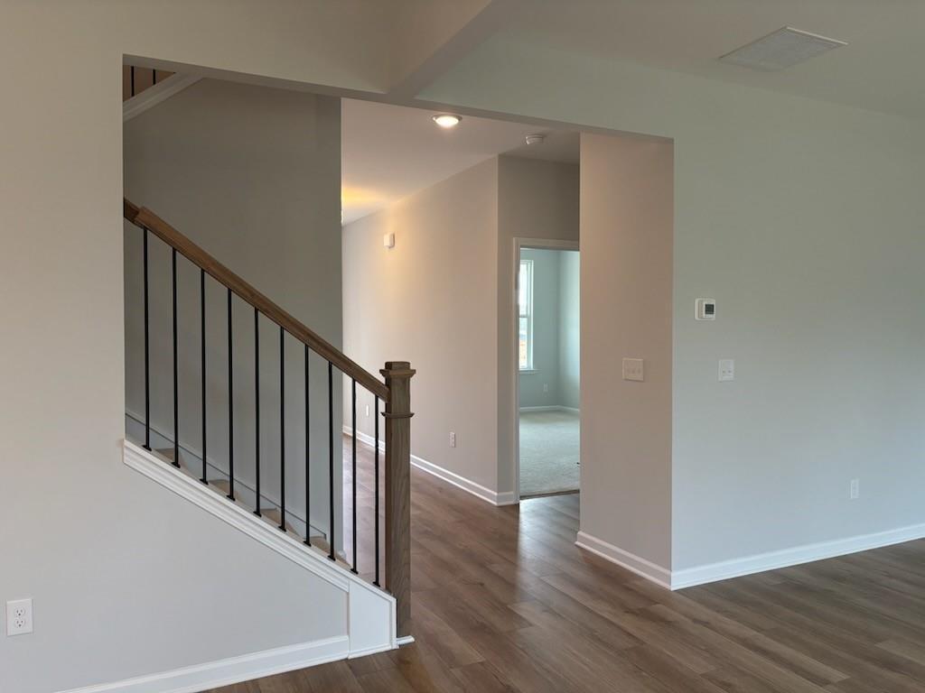 Elegant wooden staircase with black iron railings in open foyer of 2-story Hickory B home by Davidson Homes, Winder GA