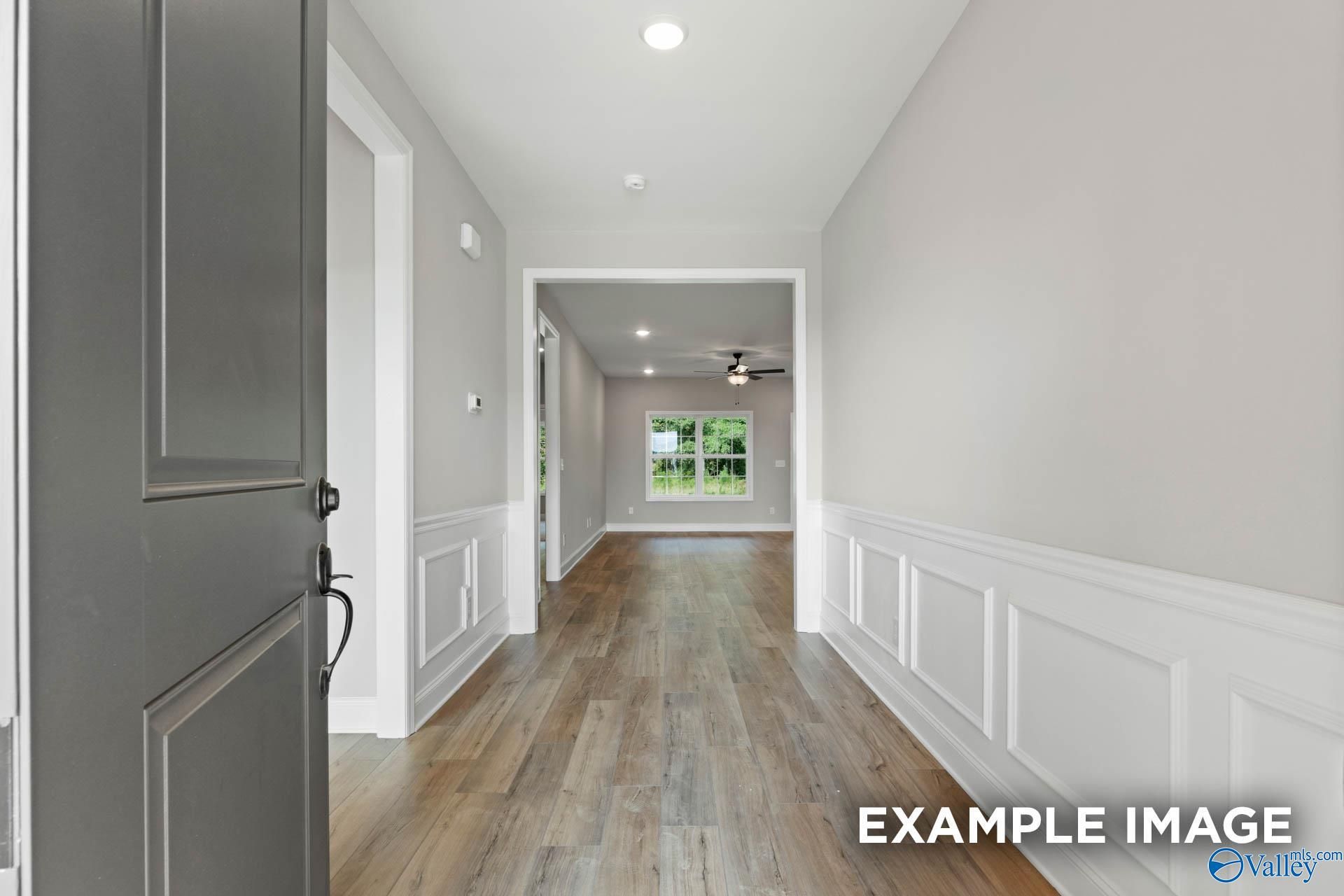 Elegant hallway with wainscoting, hardwood floors, and recessed lighting in The Montgomery B 3-bedroom home, Toney, Alabama
