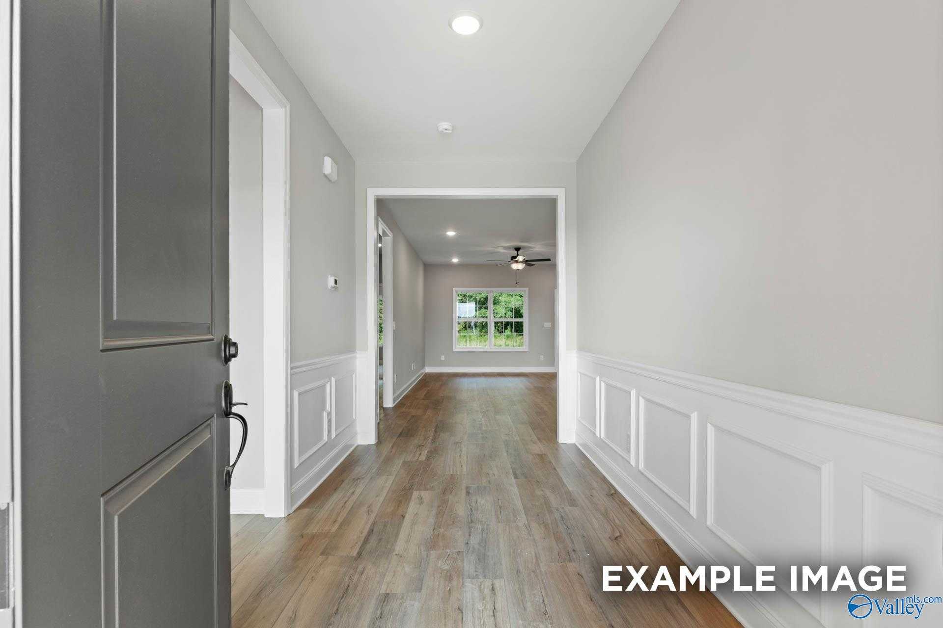 Elegant hallway with wainscoting, hardwood floors, and recessed lighting in The Montgomery B 3-bedroom home, Toney, Alabama
