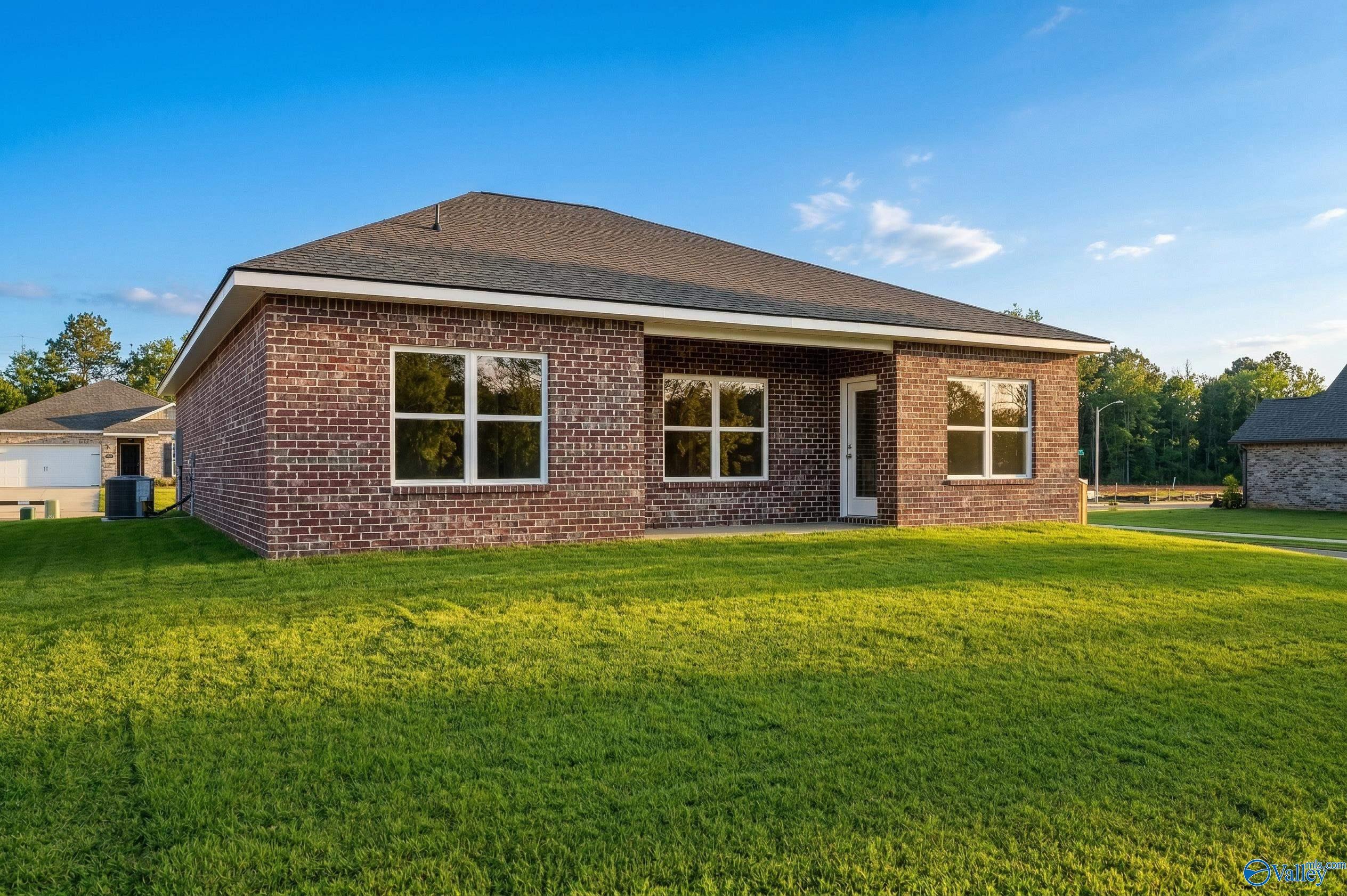 Brick exterior of the Asheville C floor plan by Davidson Homes featuring a spacious backyard in Spragins Cove, Huntsville.