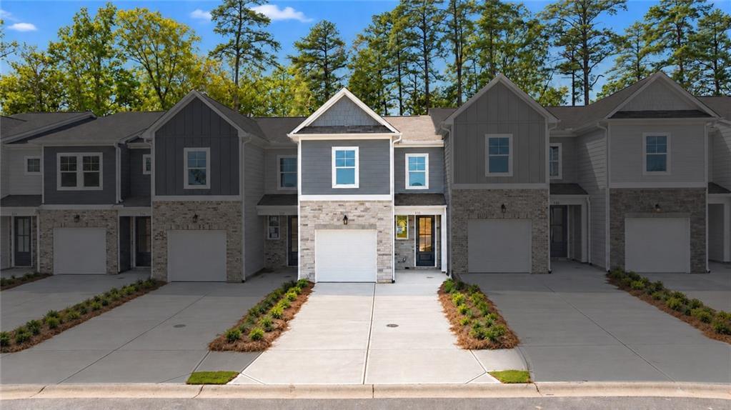 Row of modern two-story townhomes with stone accents and attached garages in Stegall Village, Davidson Homes, Emerson, Georgia