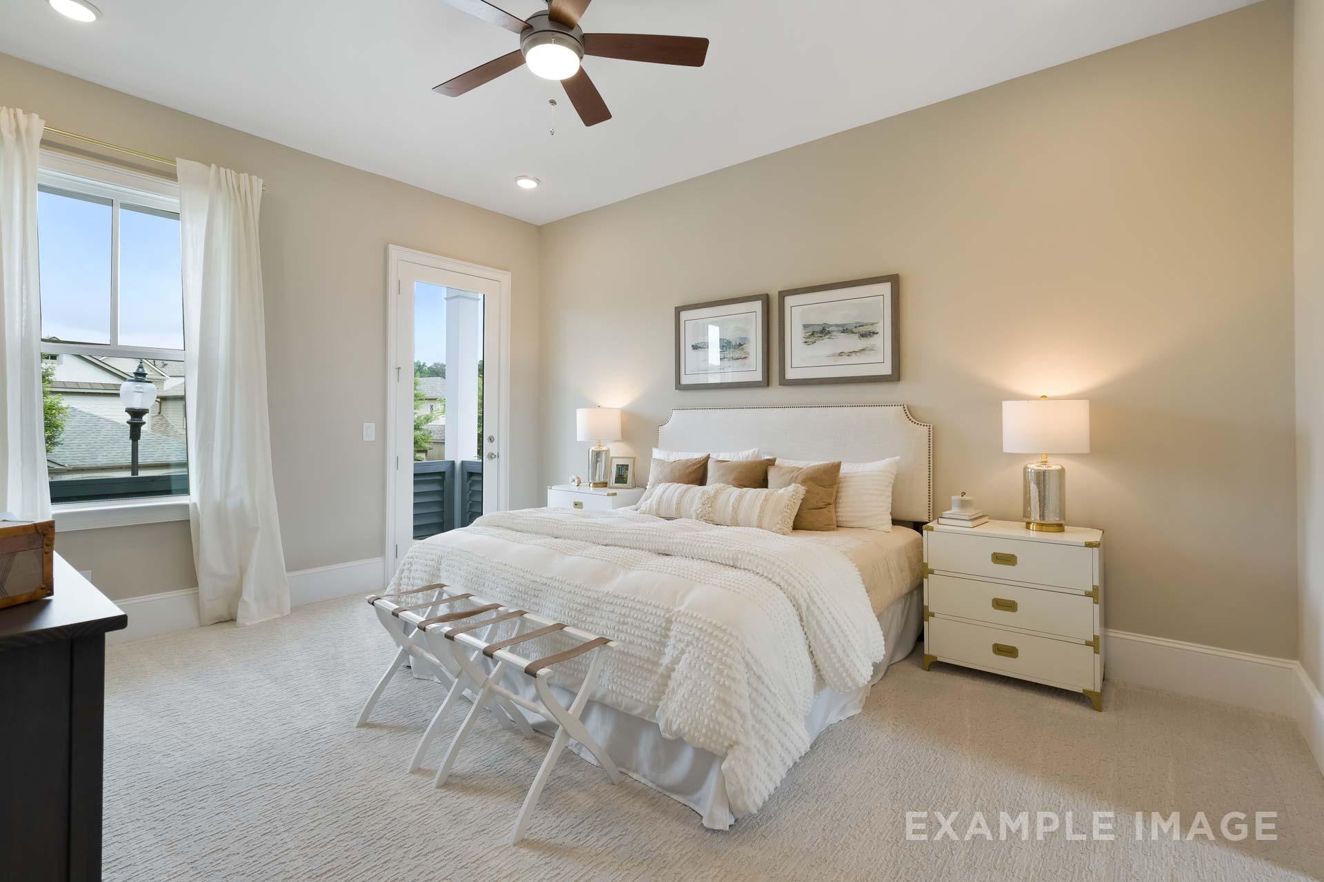 Spacious master bedroom in The Seaside C featuring king bed, balcony access, and beige walls