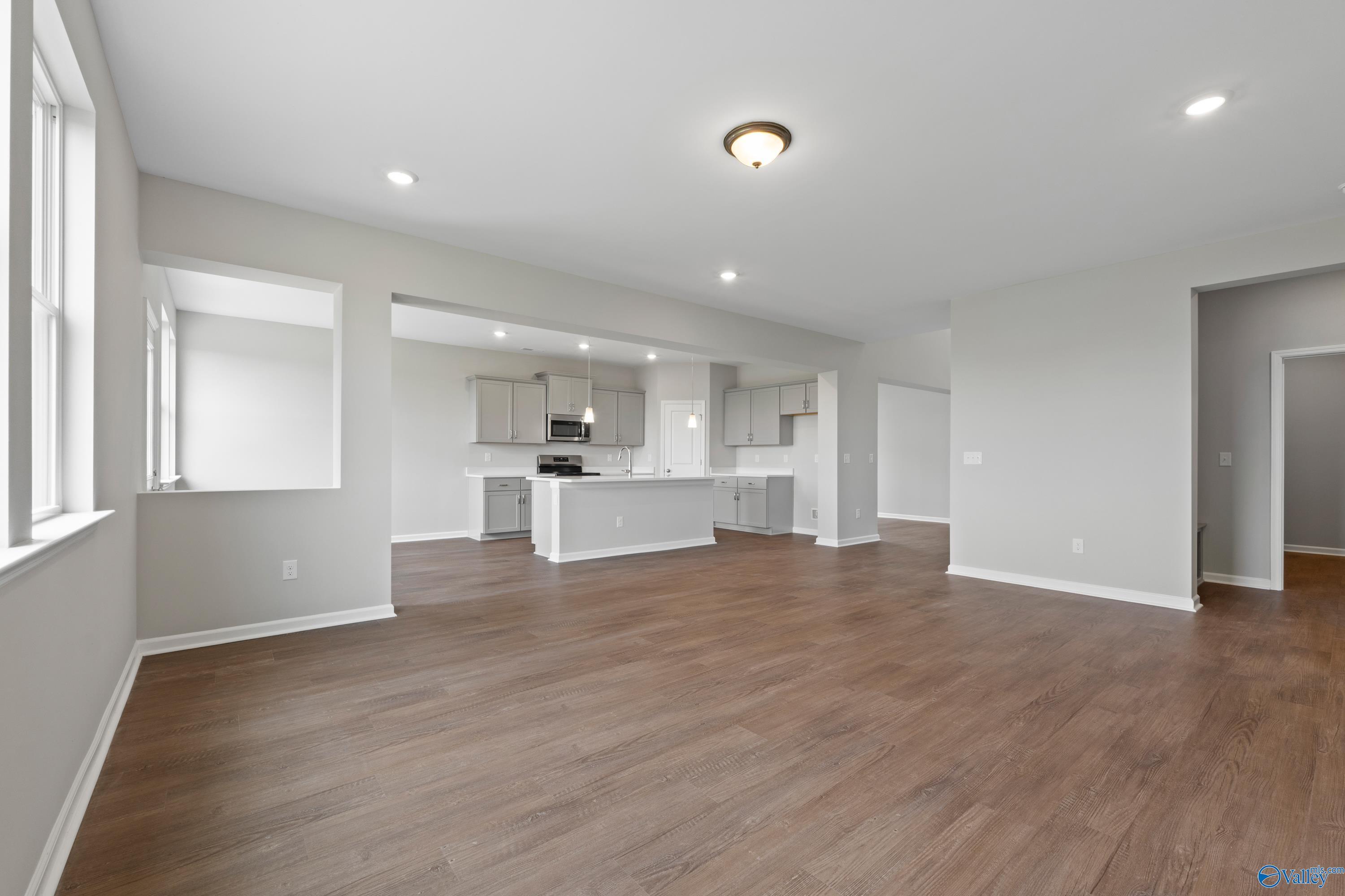 Open-concept kitchen with large center island, light cabinets, hardwood floors in Davidson Homes The Dorado, Athens AL