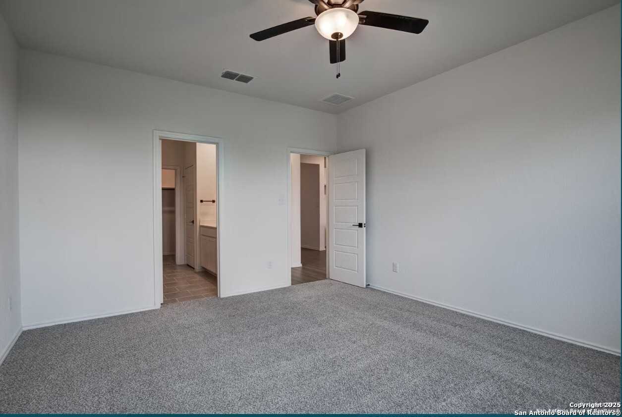 Bright master bedroom with ceiling fan, en-suite bathroom vanity, and double doors in The Daphne H, Seguin, Texas