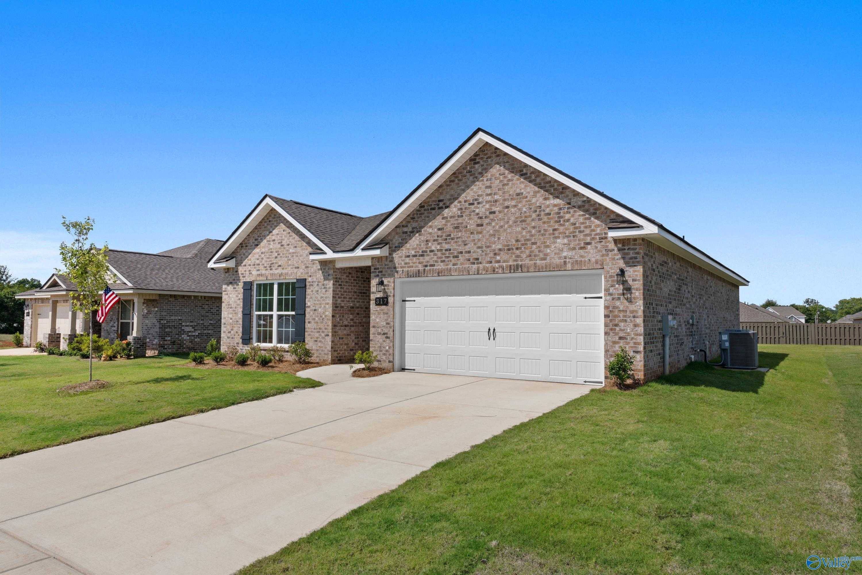 Brick single-story home with 2-car garage, driveway, and lush lawn in Clearview, Hazel Green, Alabama
