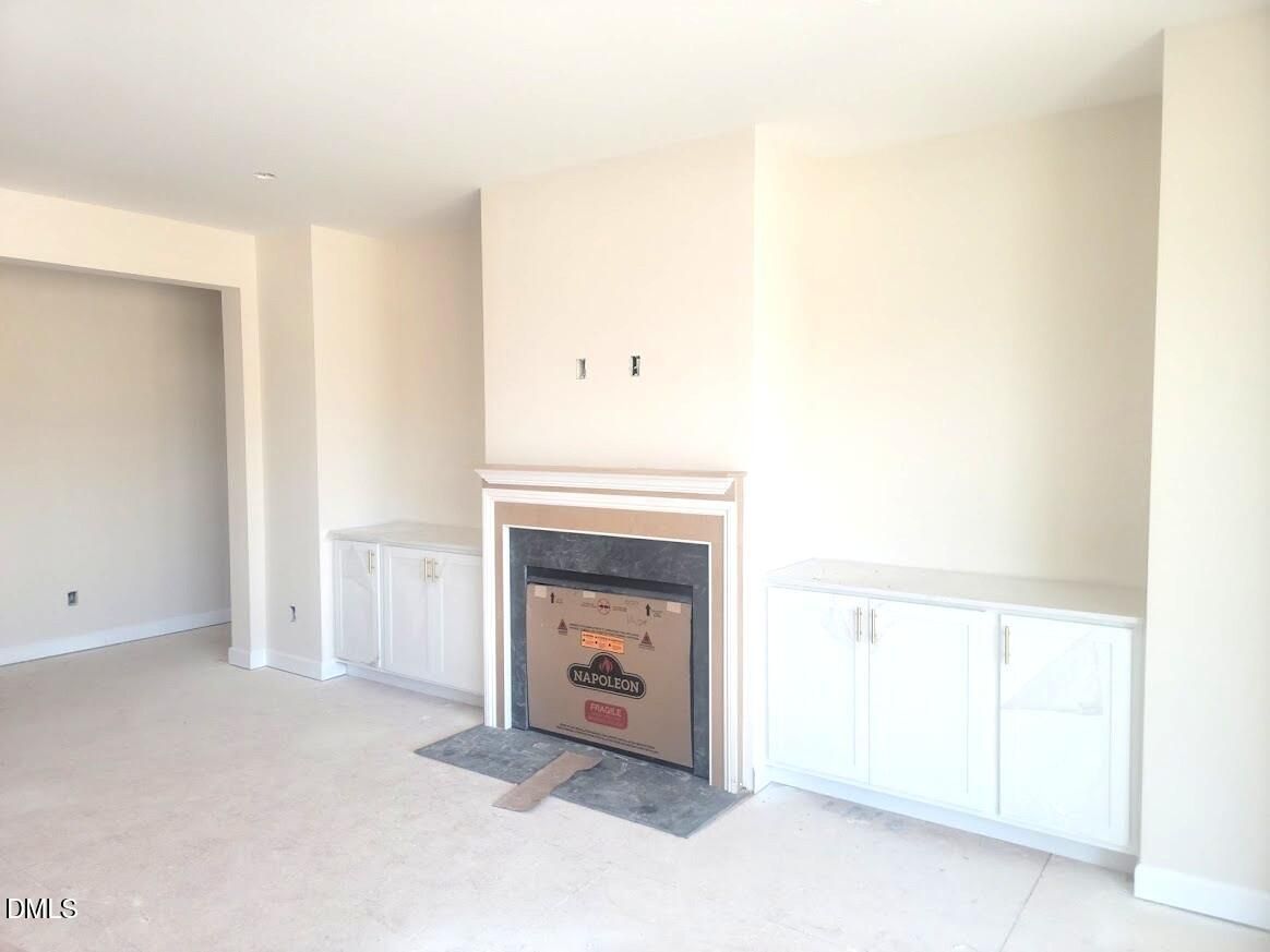 Cozy built-in fireplace with white flanking cabinets in family room of Davidson Homes The Cypress B II, Angier, NC