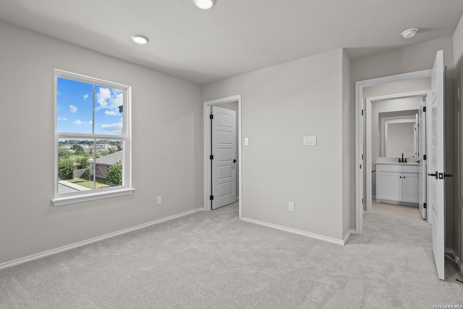 Bright bedroom with carpet and window views, adjoining bath, in Davidson Homes The Sequoia C, Royal Crest, San Antonio