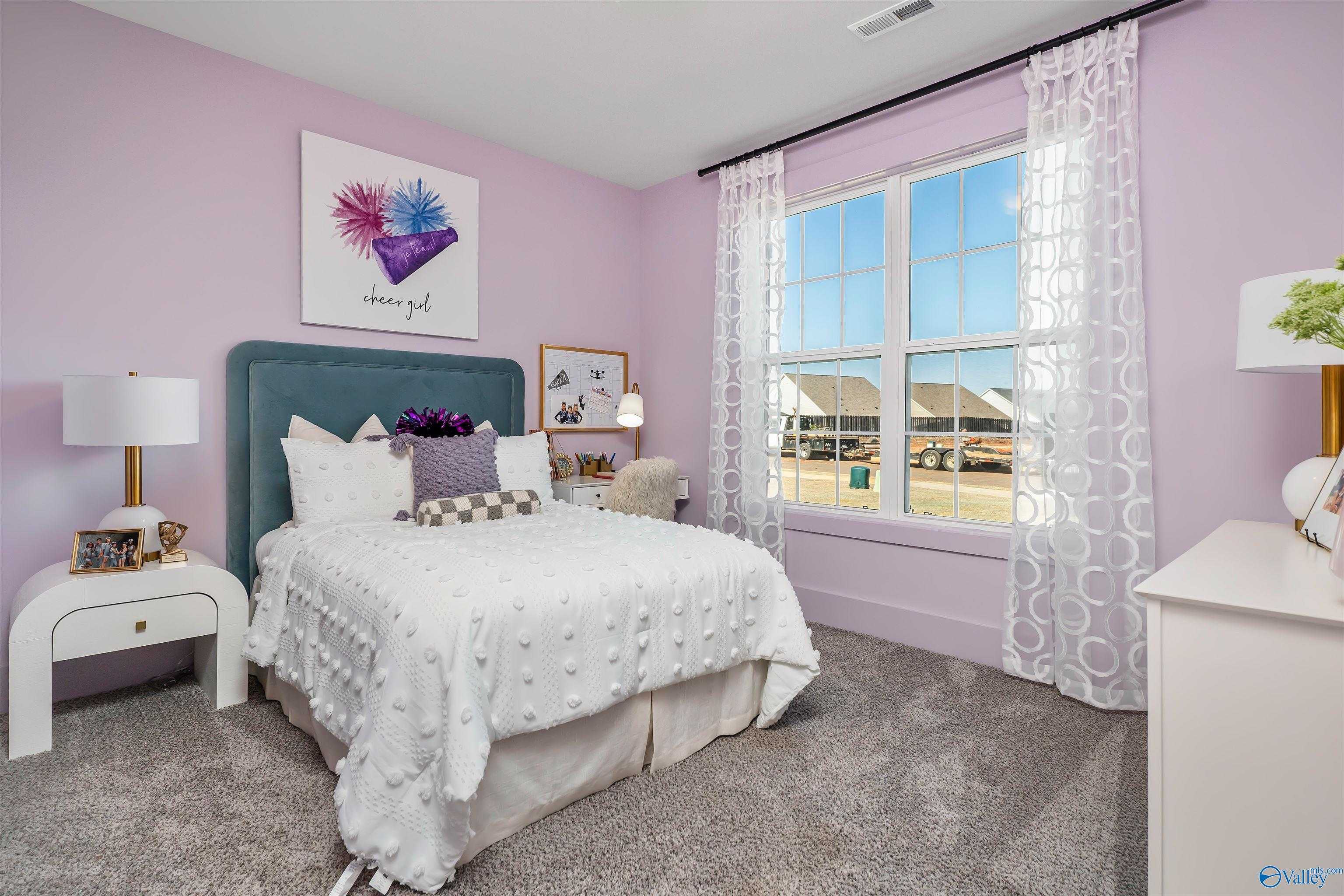 Charming purple girl's bedroom with tufted white bed, teal headboard, and window view in Davidson Homes The Rockford B, Madison, Alabama