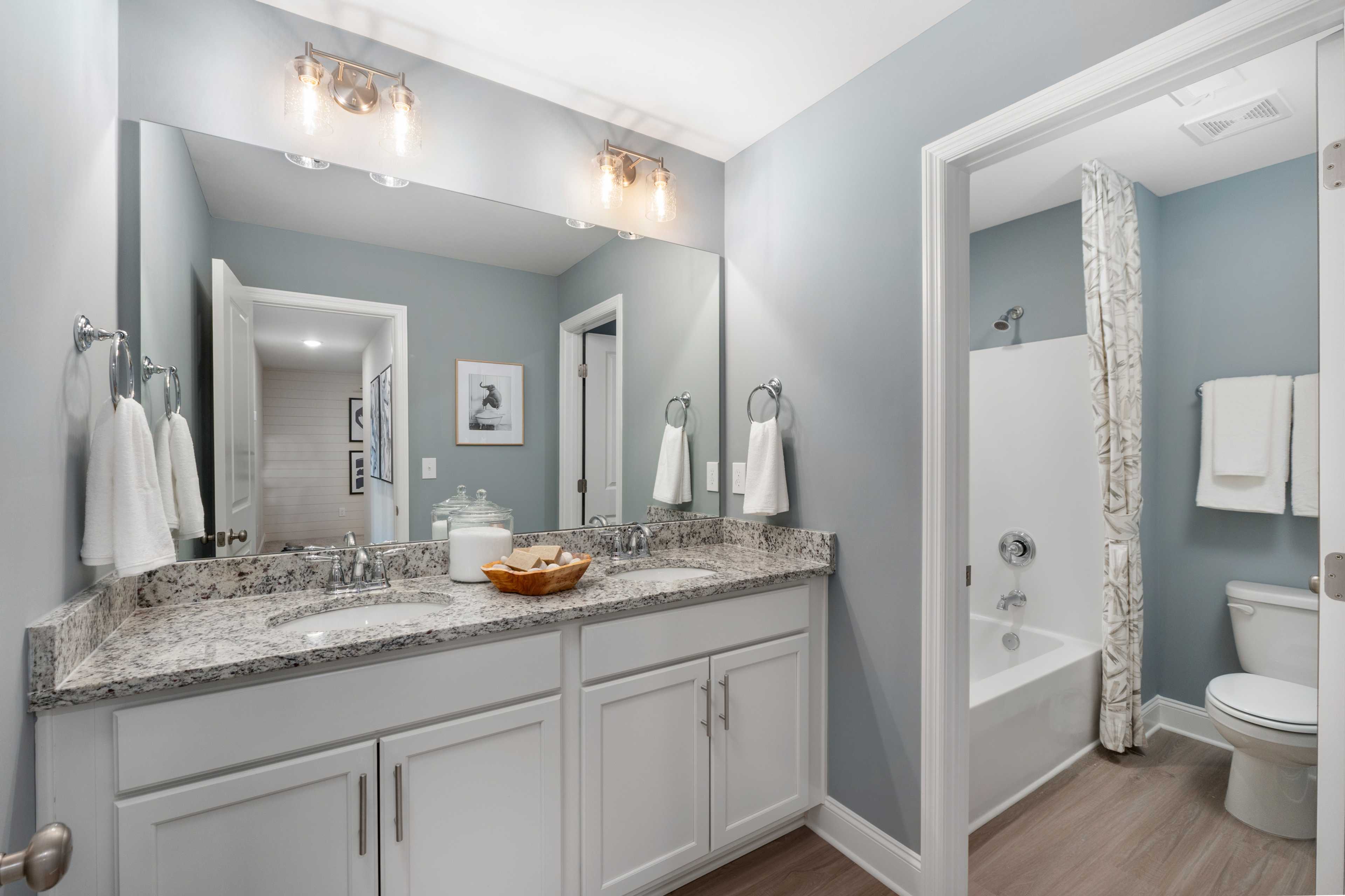 Spacious master bathroom at Pavilion in Huntsville AL by Davidson Homes with double vanity, quartz counters, and tub-shower combo