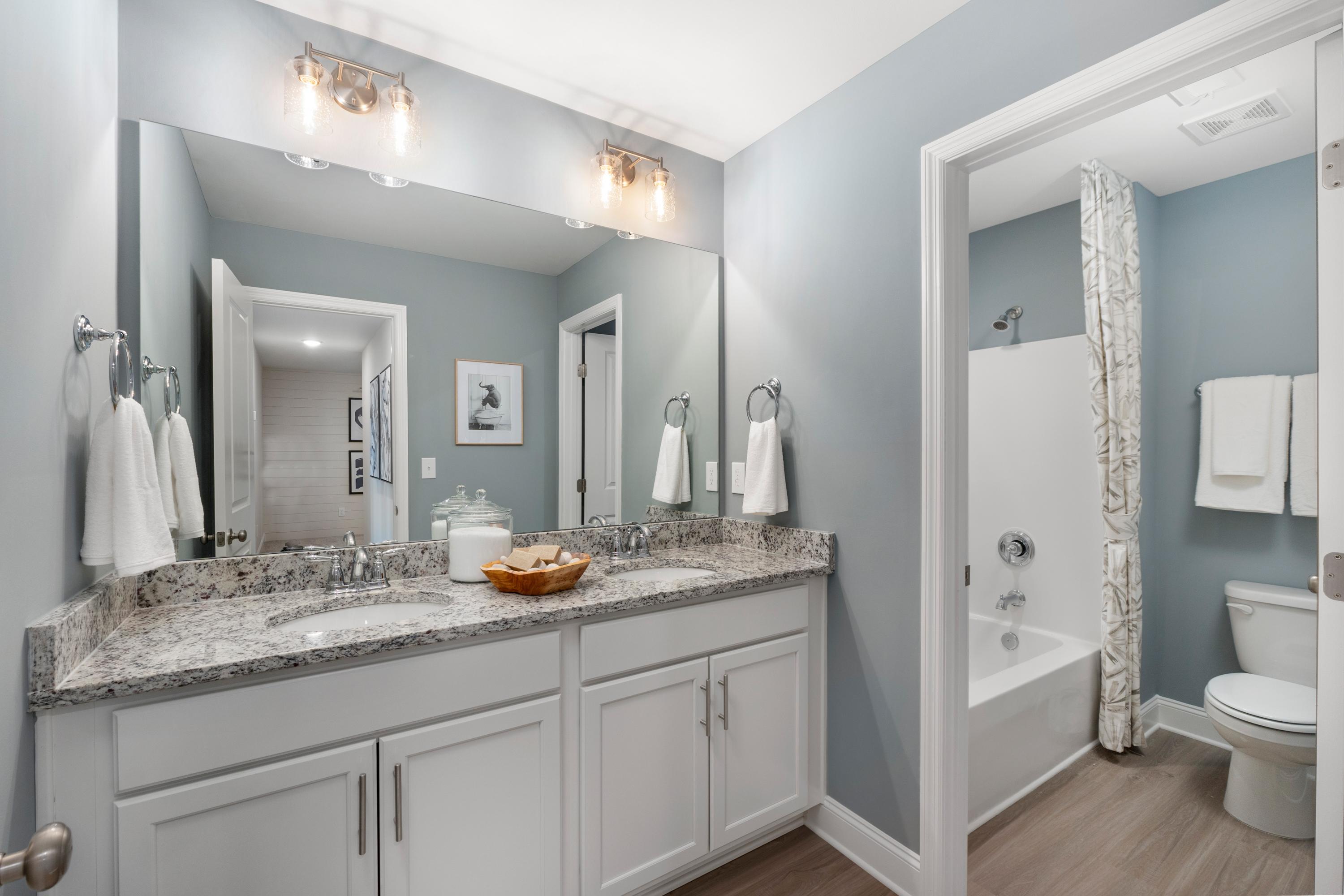 Spacious master bathroom at Pavilion in Huntsville AL by Davidson Homes with double vanity, quartz counters, and tub-shower combo