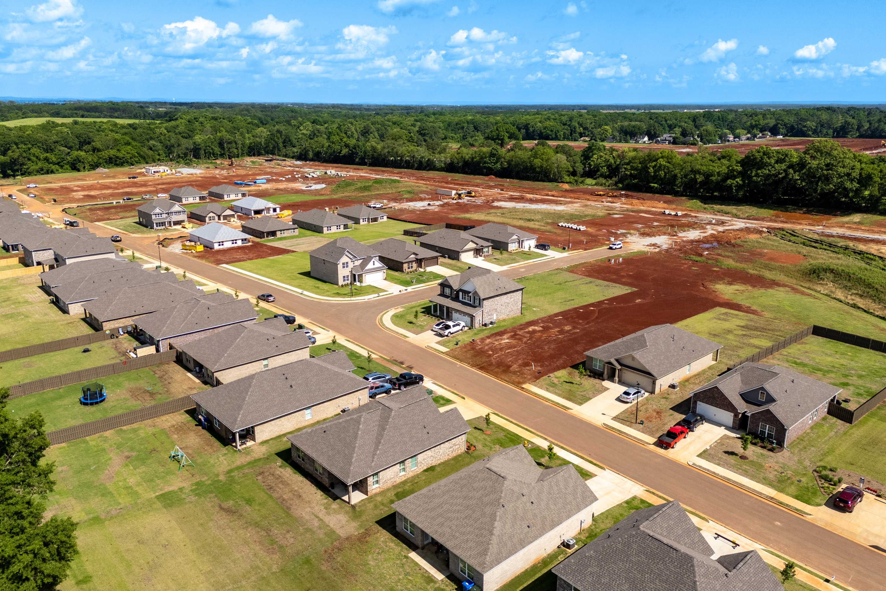 Aerial view of The Meadows neighborhood in Athens Alabama featuring new Davidson Homes amid green fields and trees
