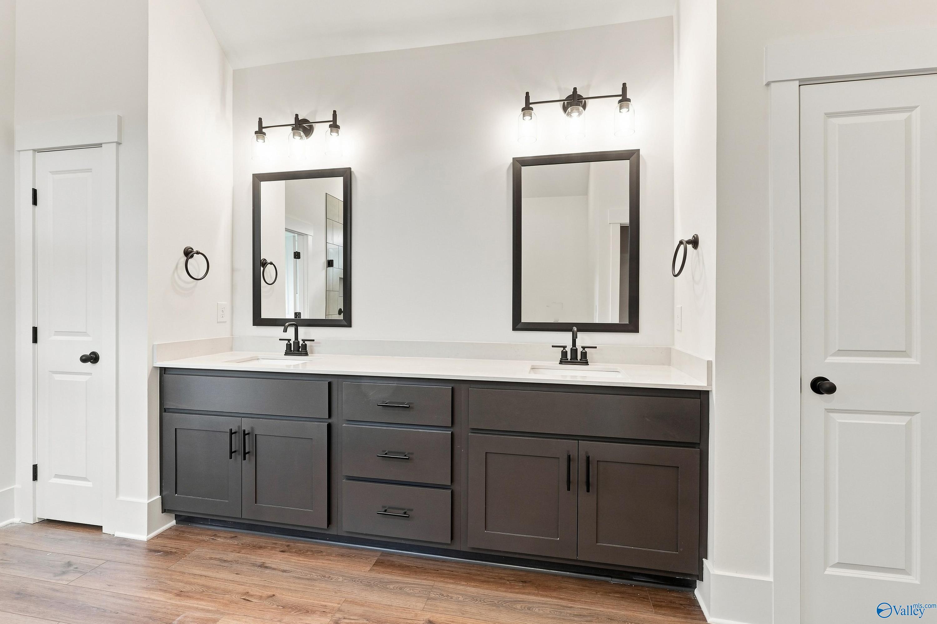 Dual vanity bathroom with dark shaker cabinets, quartz countertops, and matte black fixtures in Davidson Homes The Valencia, Huntsville
