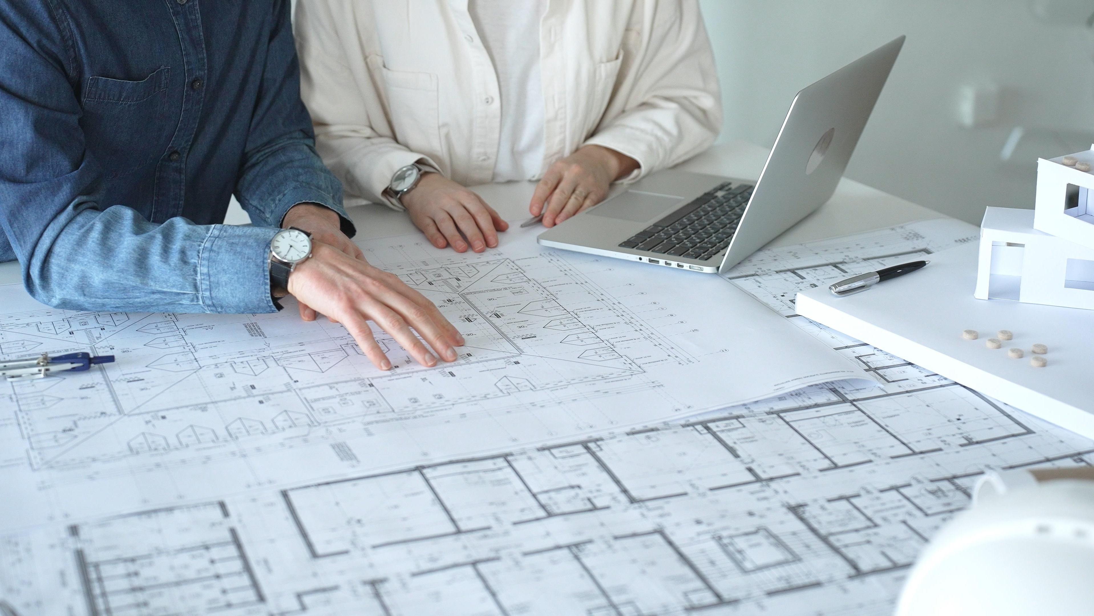 Davidson Homes team reviewing architectural blueprints and house models for Creekside Phase V development in Huntsville.