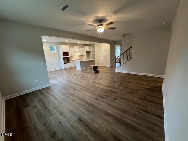 Open-concept living room with hardwood floors, ceiling fan, and kitchen view in Davidson Homes The Willow D, Lillington, NC