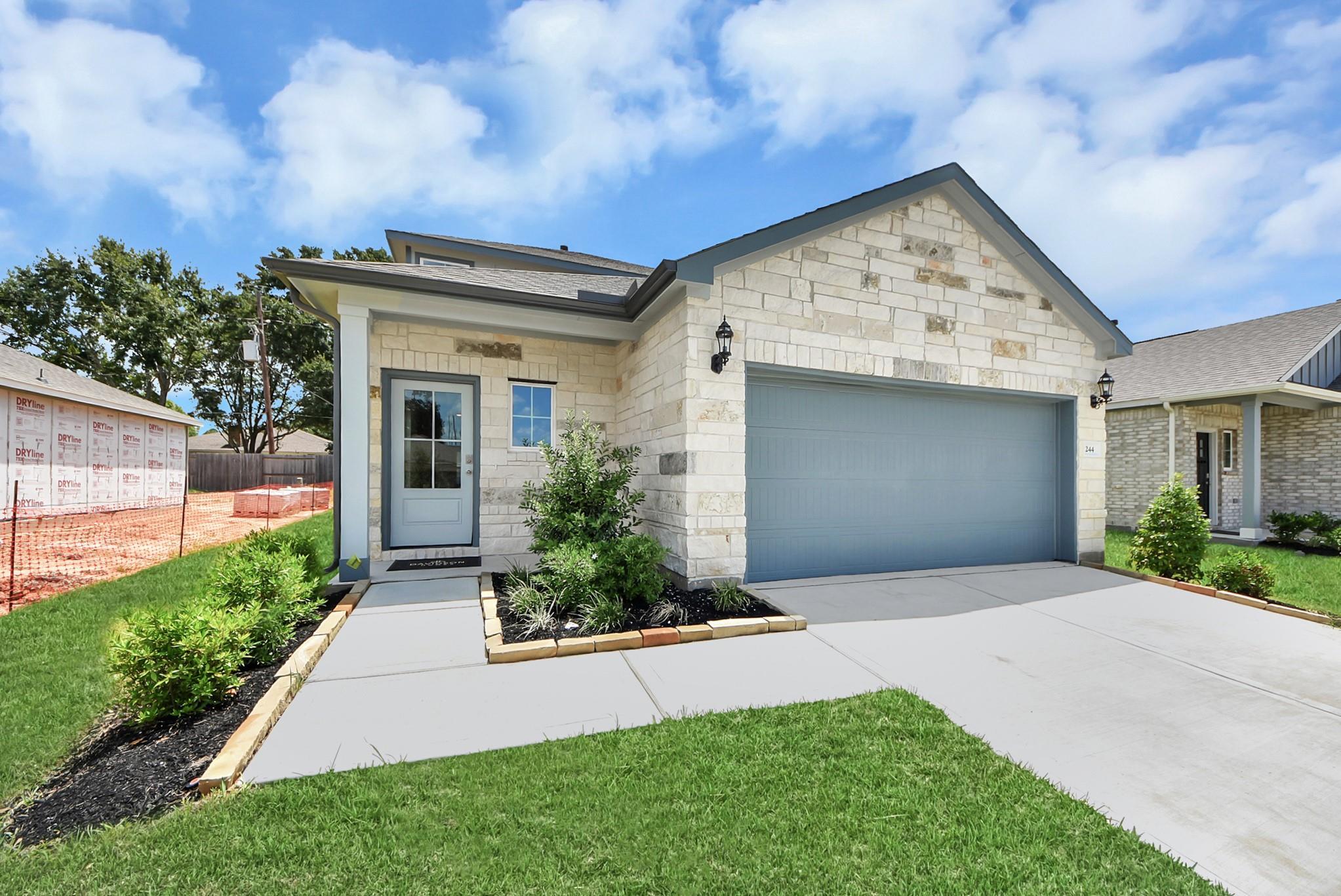 The Sabine E floor plan by Davidson Homes in Windmill Estates, Magnolia, Texas, featuring a stone facade and 2-car garage.